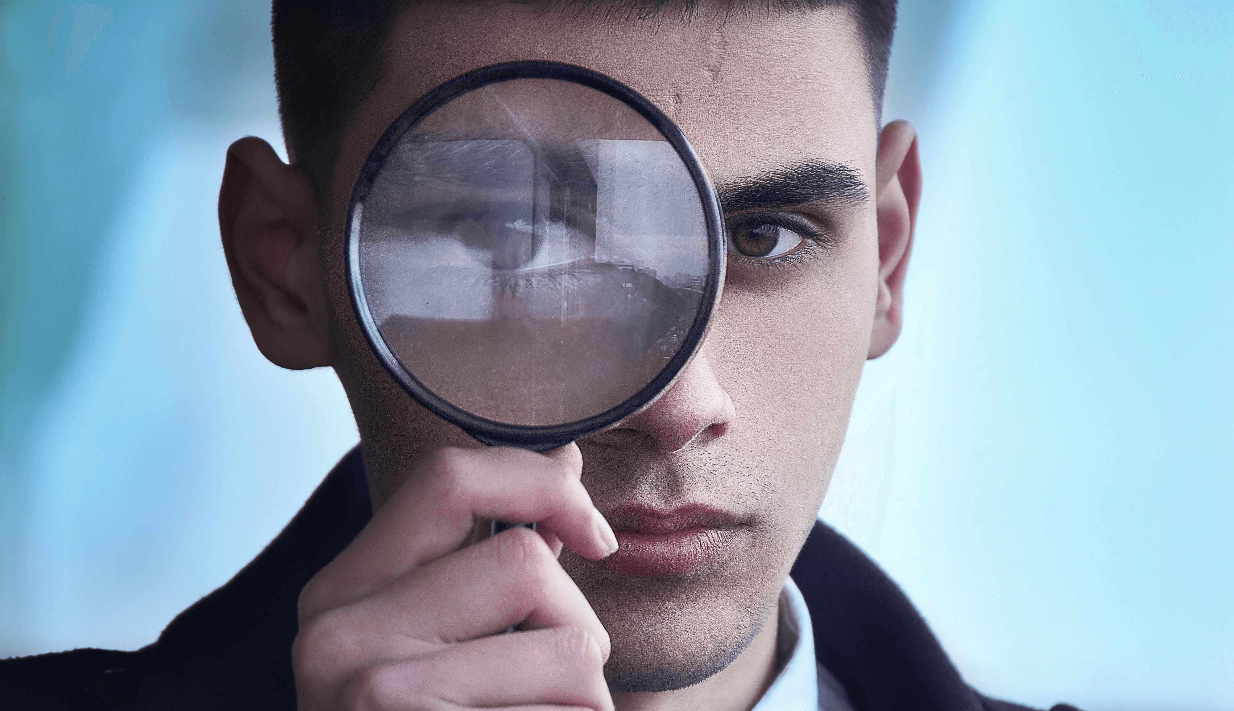 man in black suit holding magnifying glass
