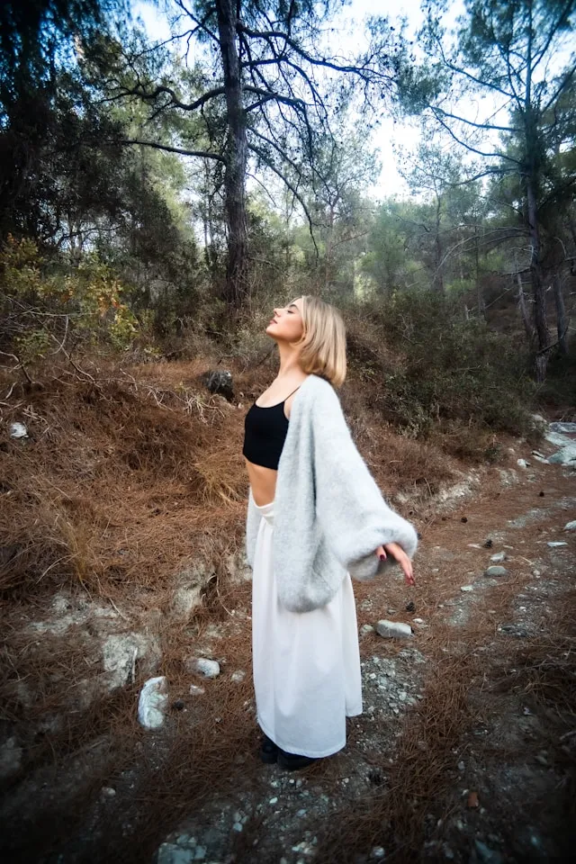 Woman standing outdoors in activewear on a dry hillside trail