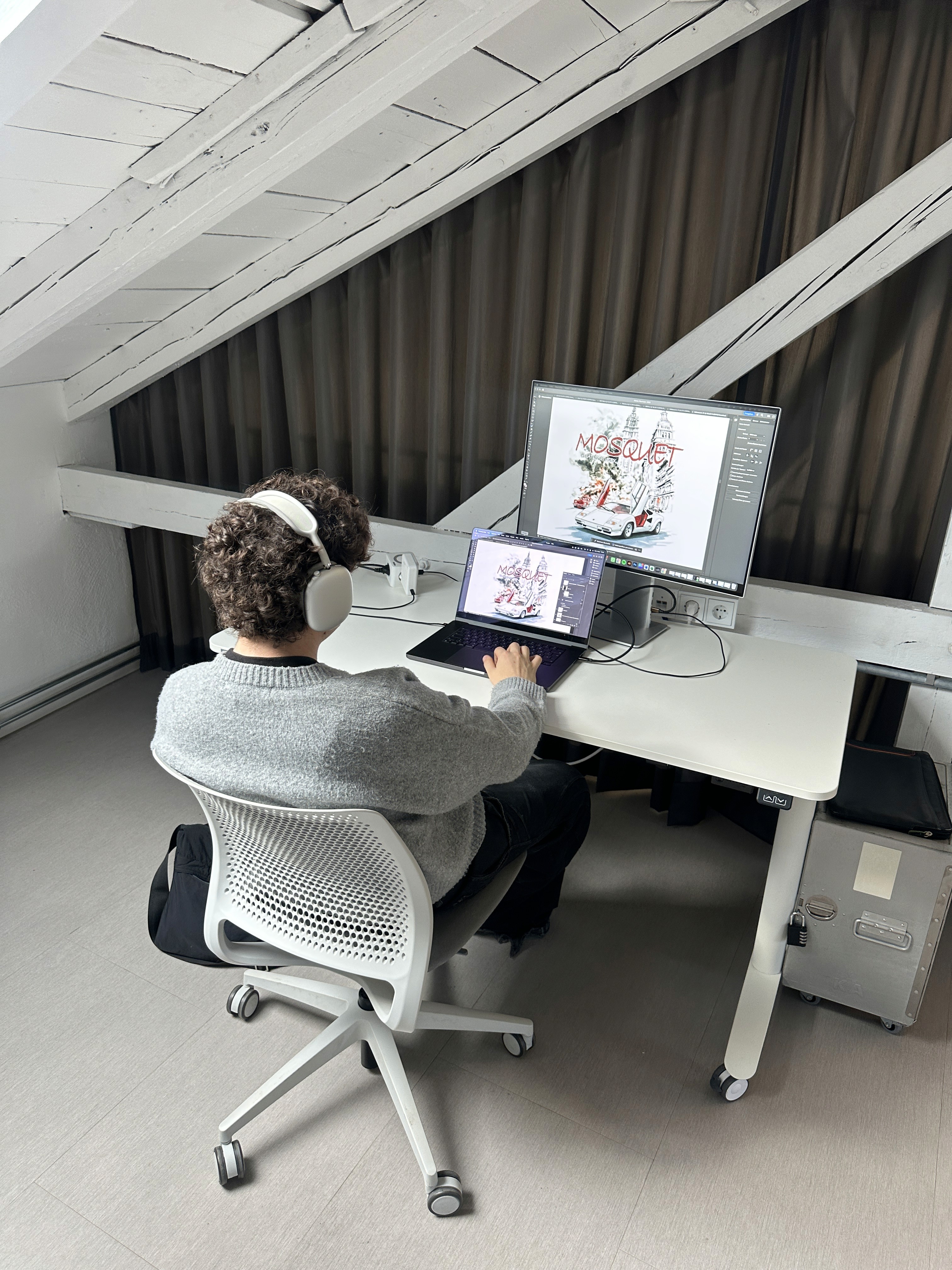 two people in a workspace working on their laptops