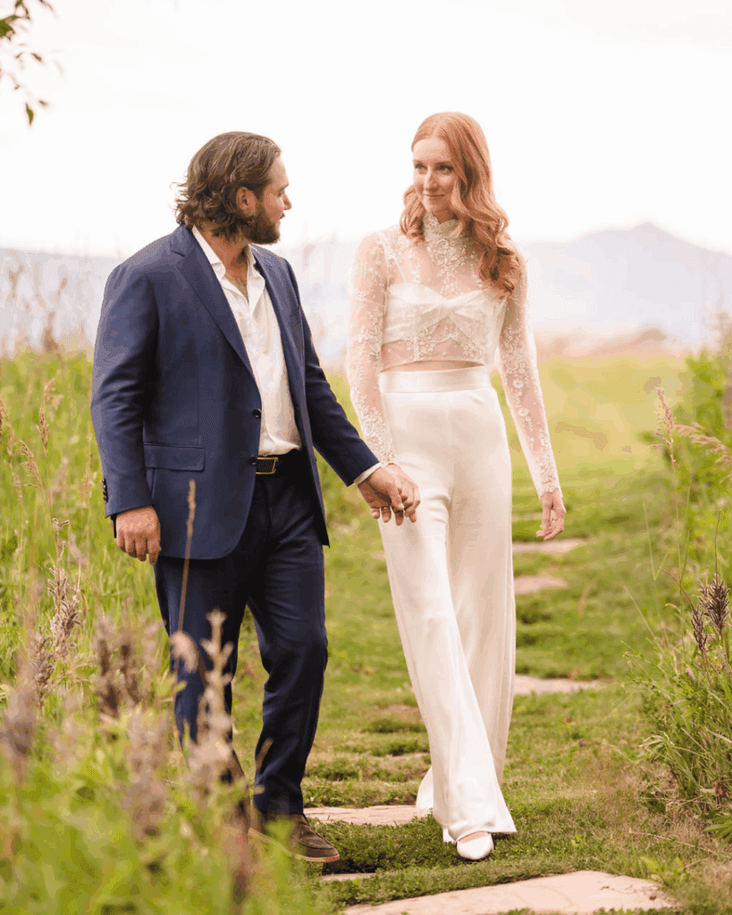 Newlyweds holding hands while walking along a stone path