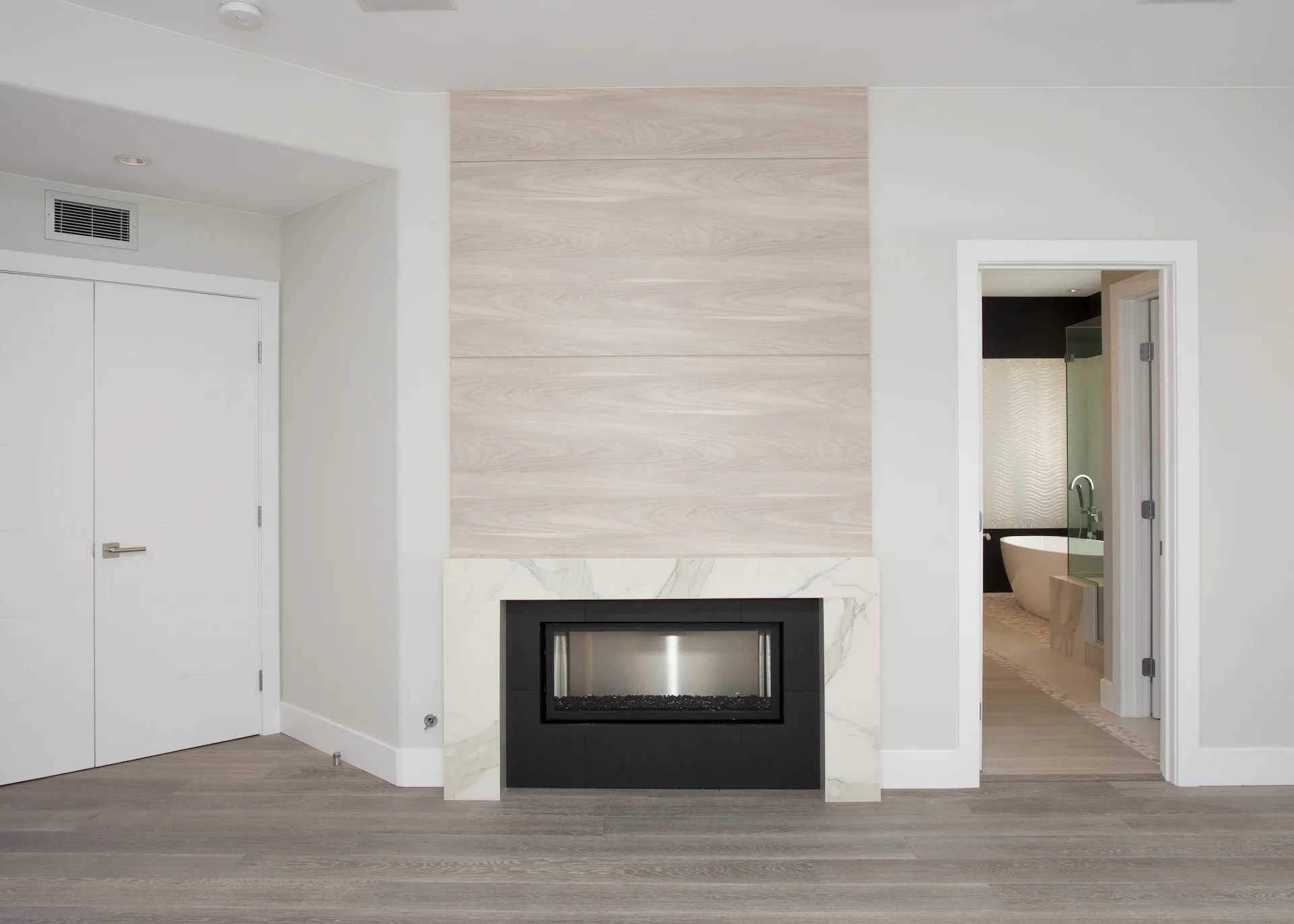 Close-up view of the master bedroom's fireplace wall, a modern feature that adds warmth and style to this Newport Beach home.