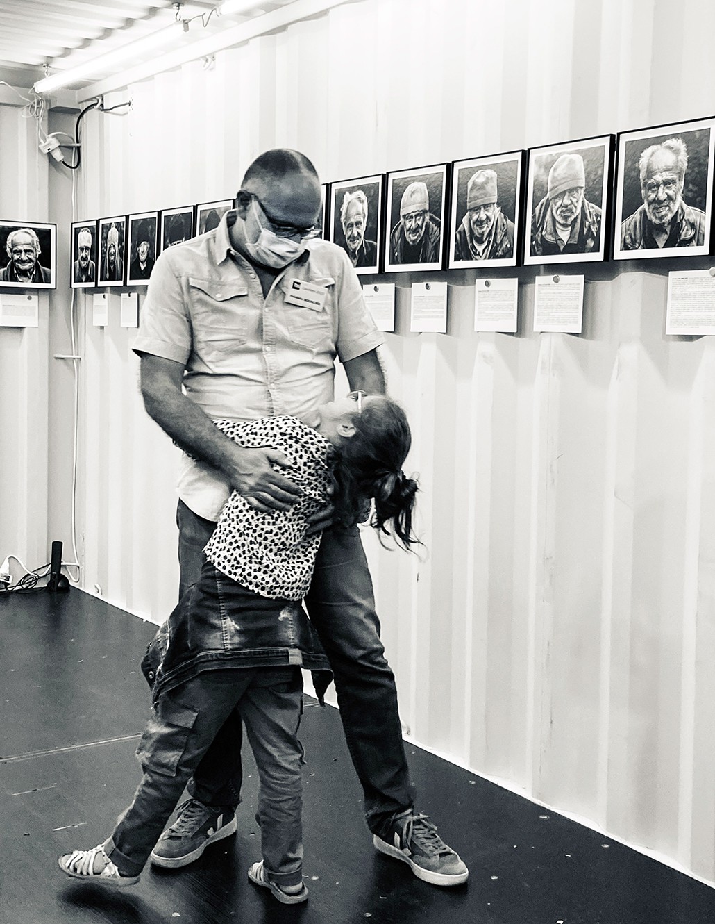 Groupe de visiteurs observant l’exposition photo de Frédéric Bourcier à l’Hôtel de Région de Lyon, dans un vaste hall moderne baigné de lumière naturelle.