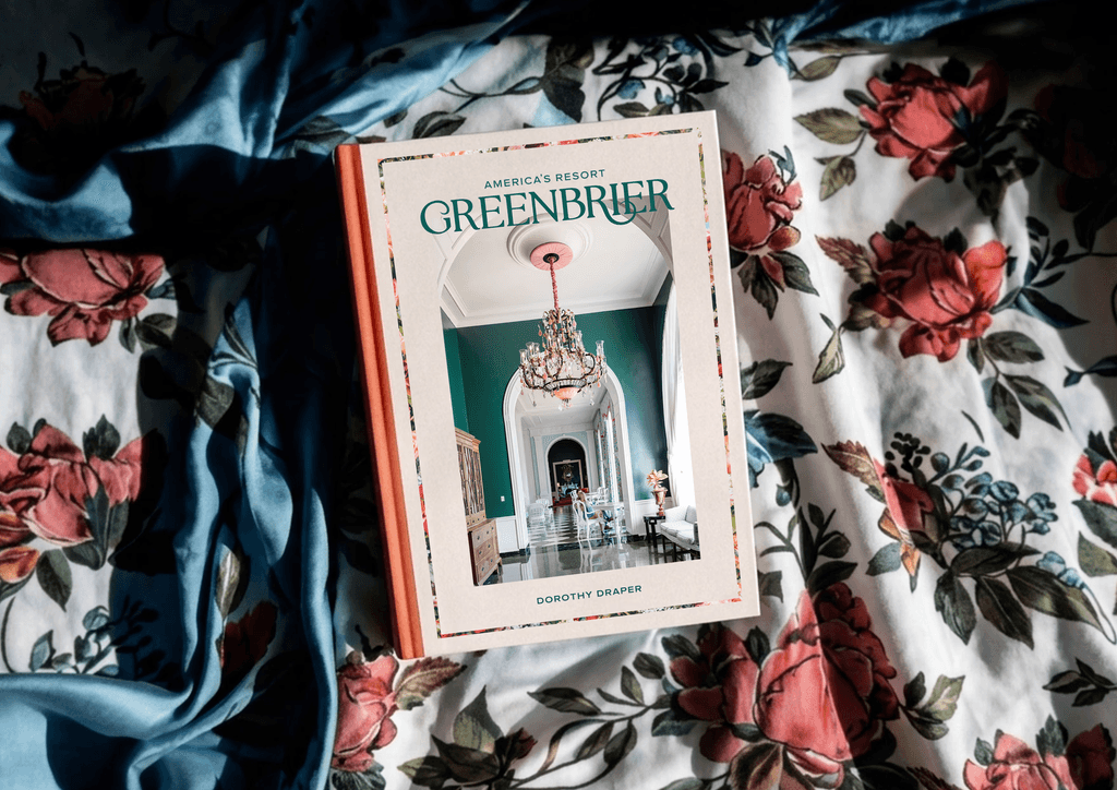 Greenbrier coffee table book resting on floral bed cover.