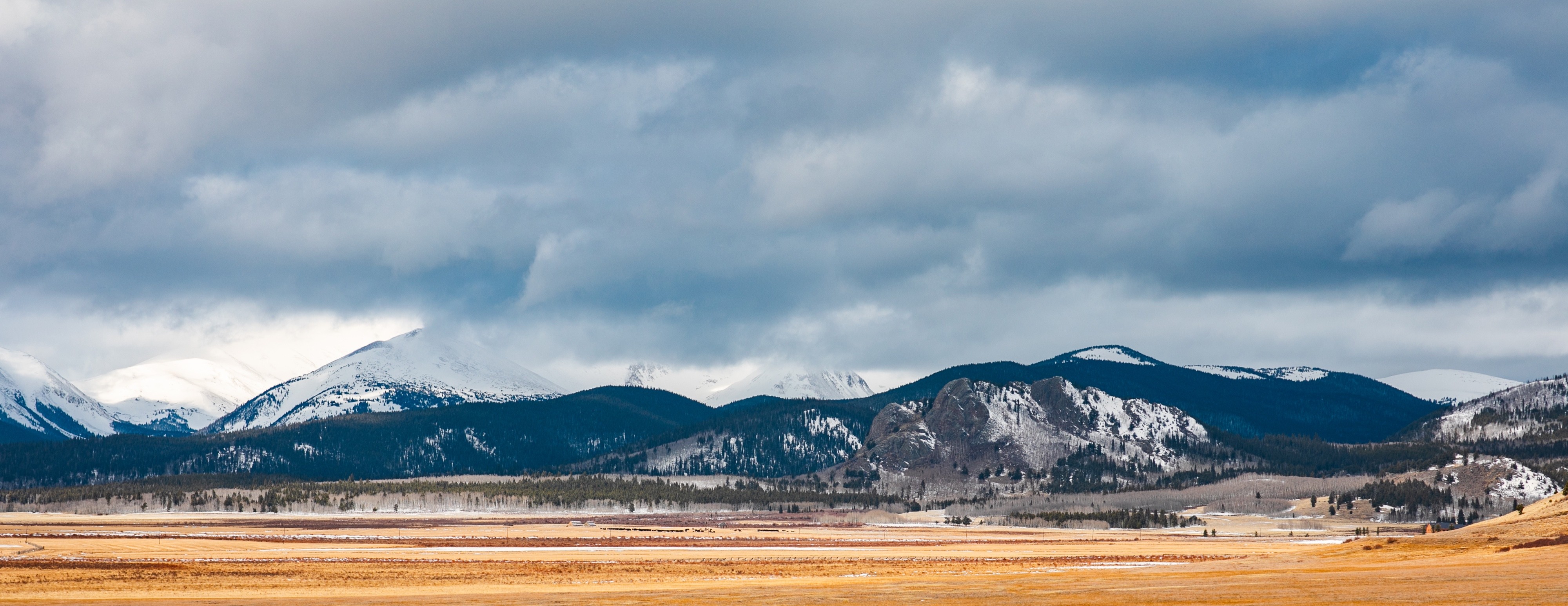 Panoramic landscape photograph of mountains, water, desert, or coast by Lucas Jensen