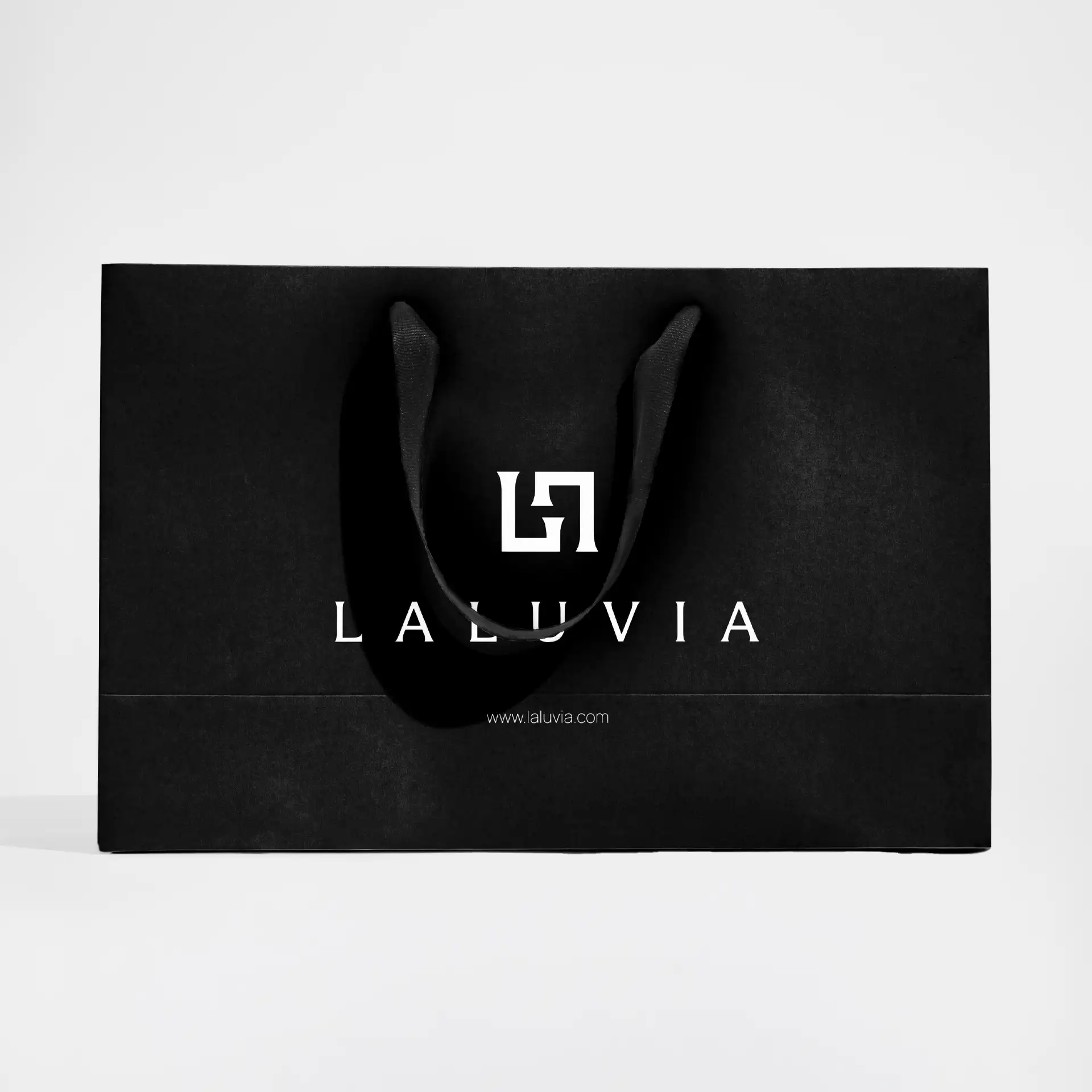 Minimalist black Laluvia retail shopping bag featuring the white brand logo and website URL.