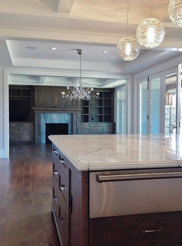 Image of Luxury kitchen interior with island, marble countertop, and pendant lights, by KHD Homes design-build team.