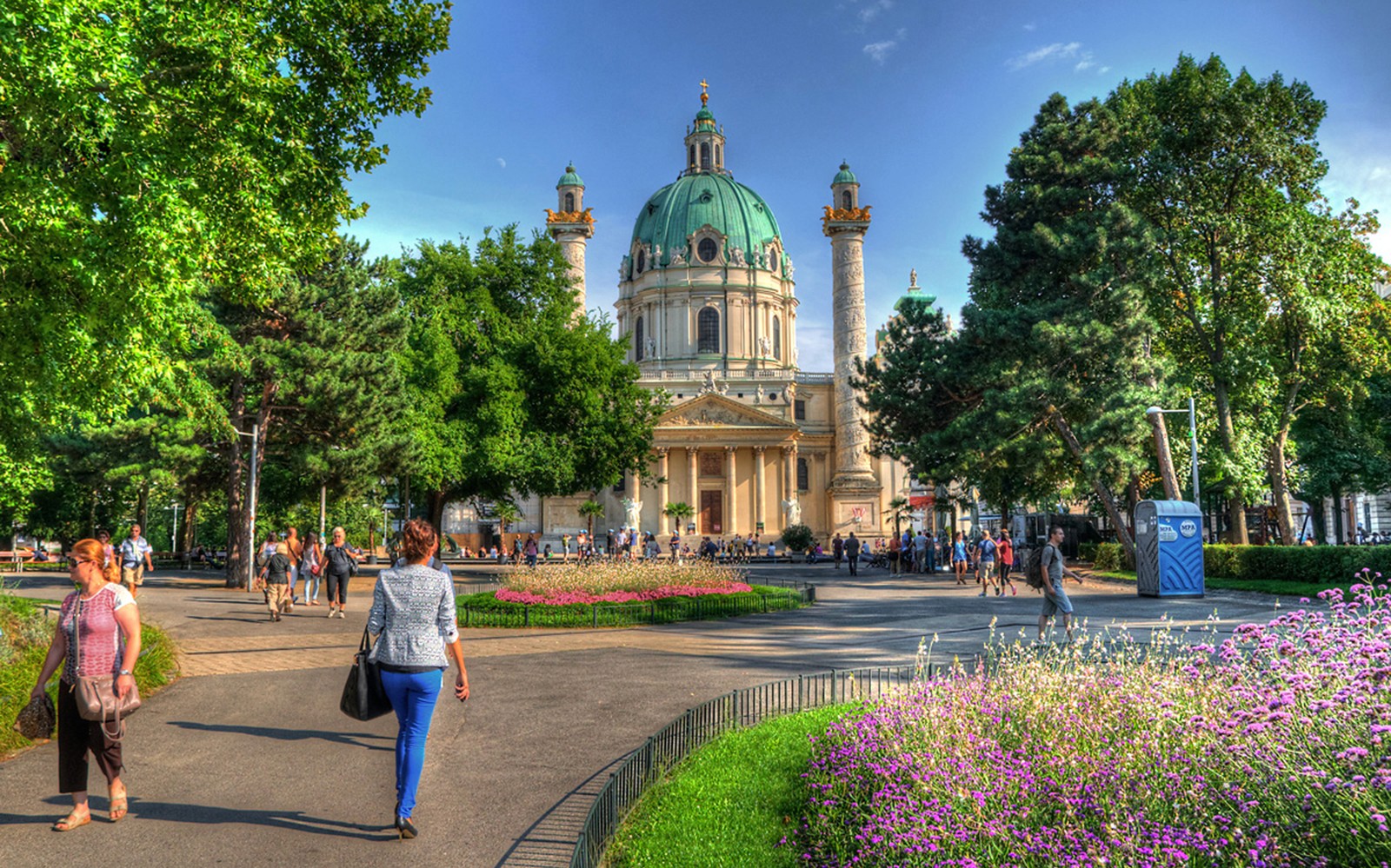 Karlskirche di Wina dengan orang-orang berjalan di taman, lokasi konser Vivaldi’s Four Seasons.