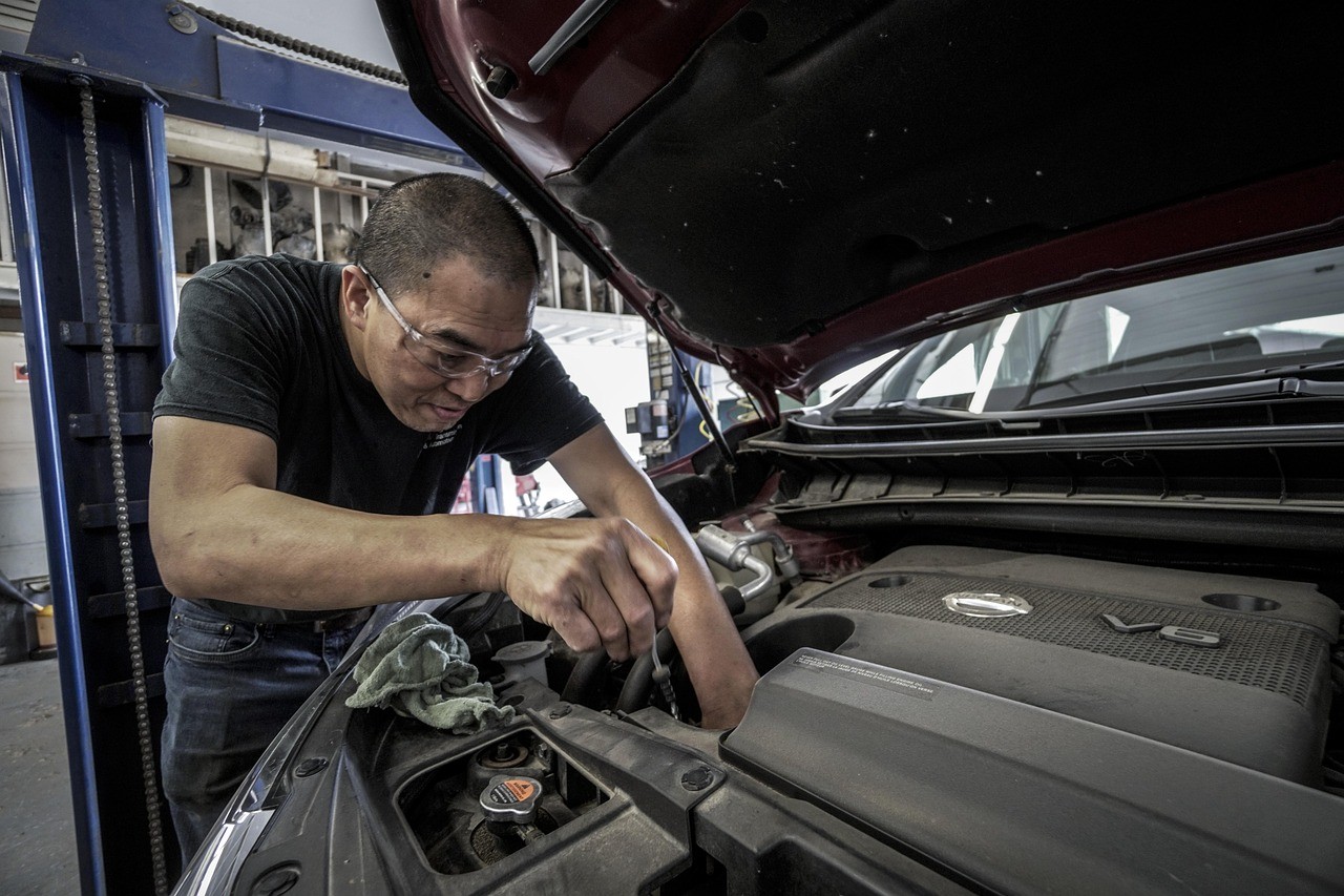 A mechanic works on a car engine.