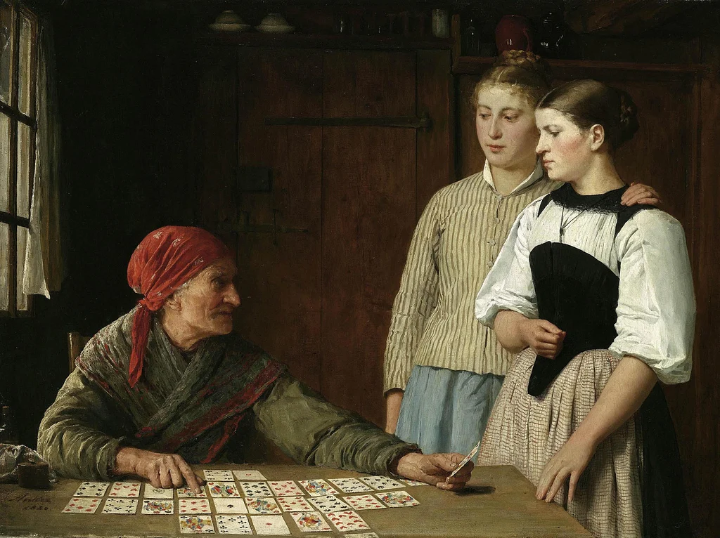 A classical oil painting of an elderly fortune teller in a red headscarf laying out playing cards on a table. Two young women in 19th-century peasant dress stand nearby looking on.
