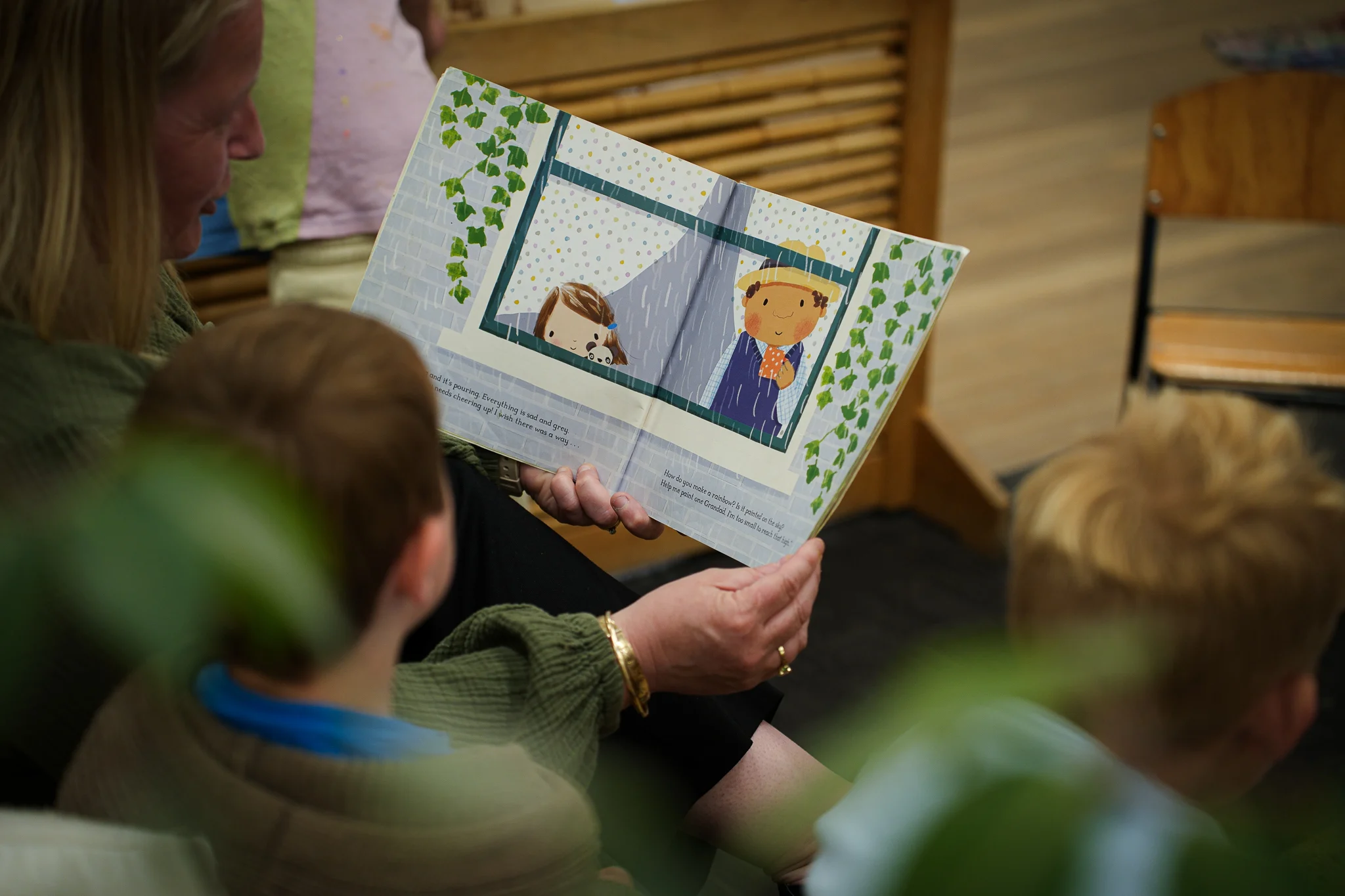 A teacher reading an illustrated book with young children during group time.