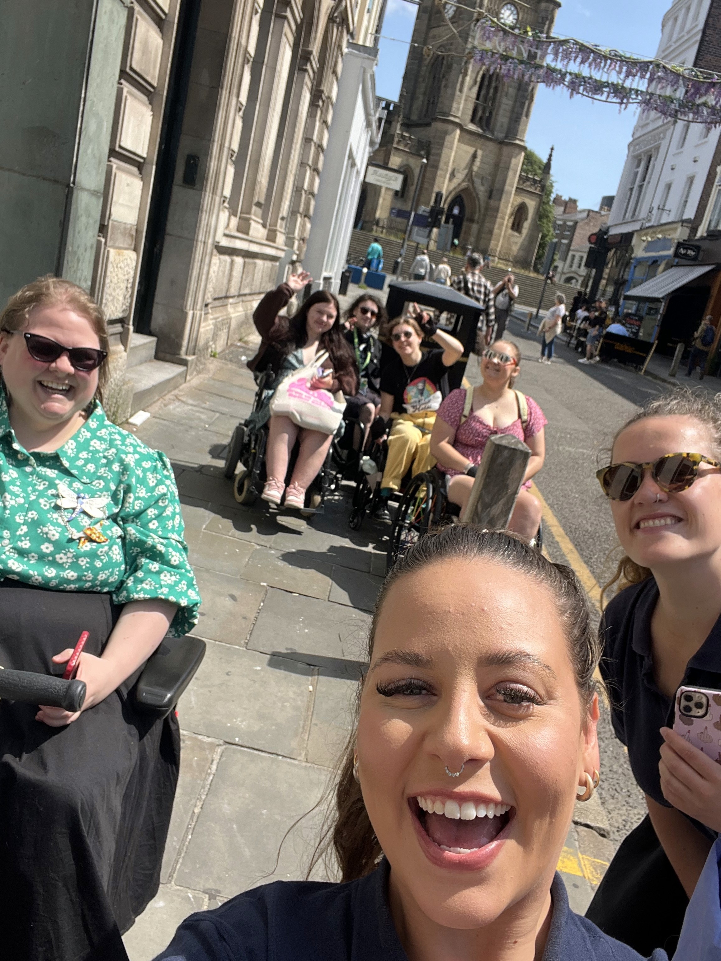 The Sociability team taking a group photo with their arms raised in the air. Everyone has big smiles on their faces.