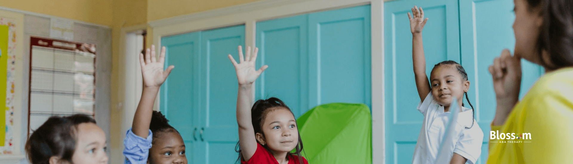 Autistic children raising hands enthusiastically during ABA therapy with ABA therapist in Georgia.