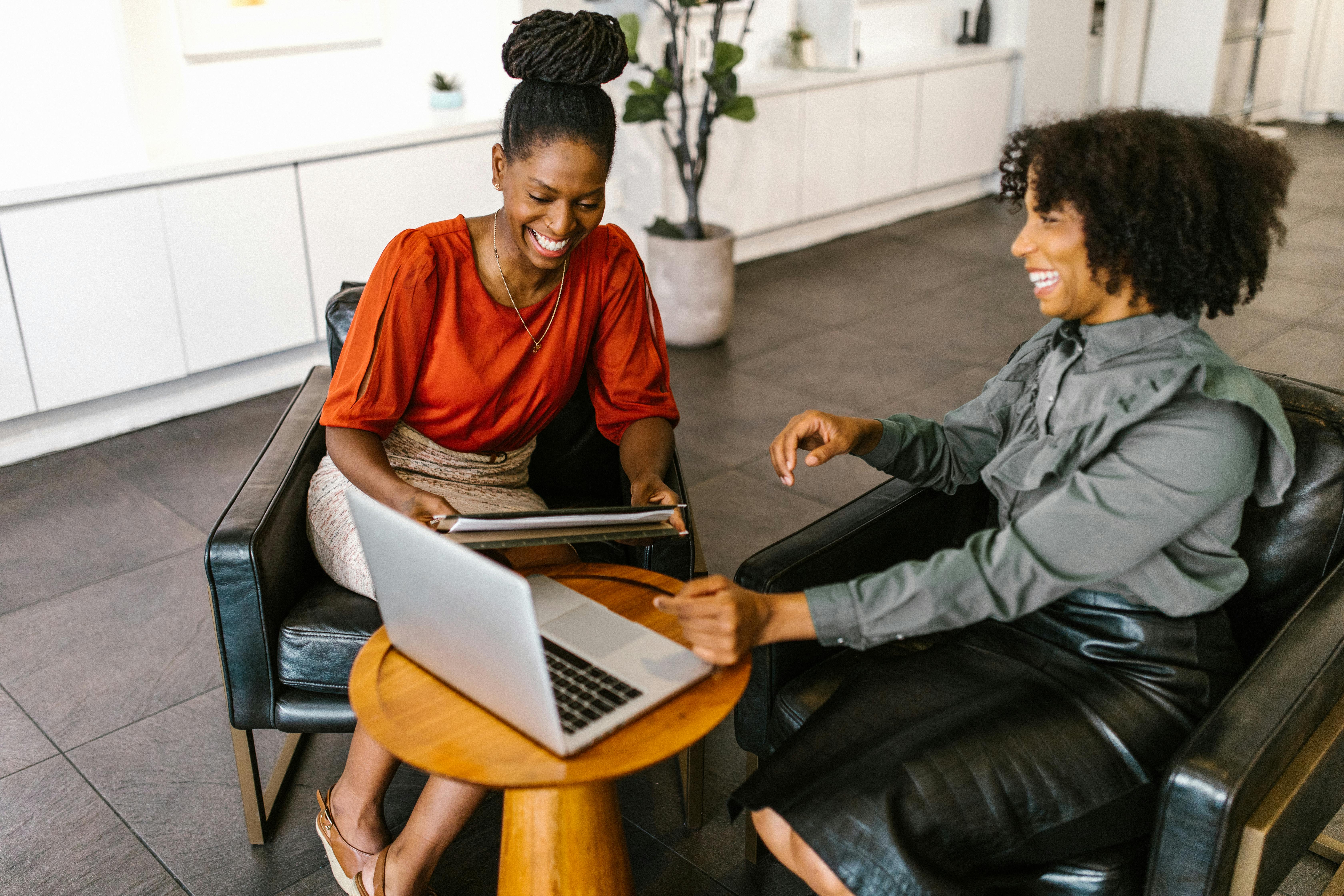 two women using laptops