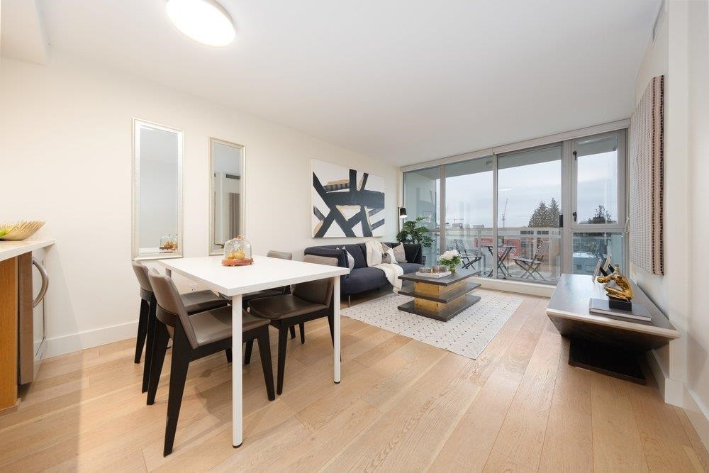 A modern interior space featuring a dining table, chairs, and a large window with a view.