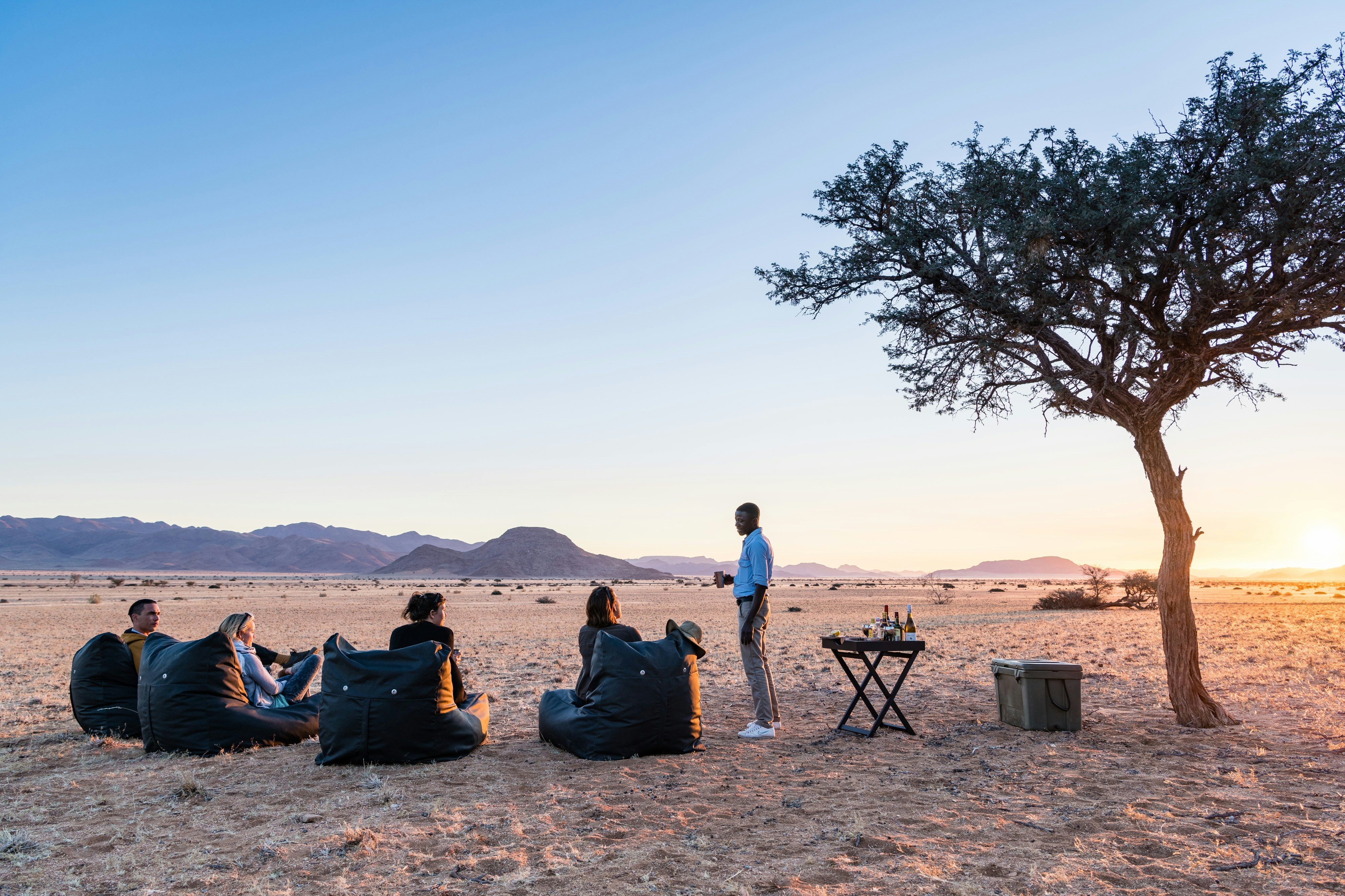 Travellers sitting and talking around a campfire at a Namibian campsite