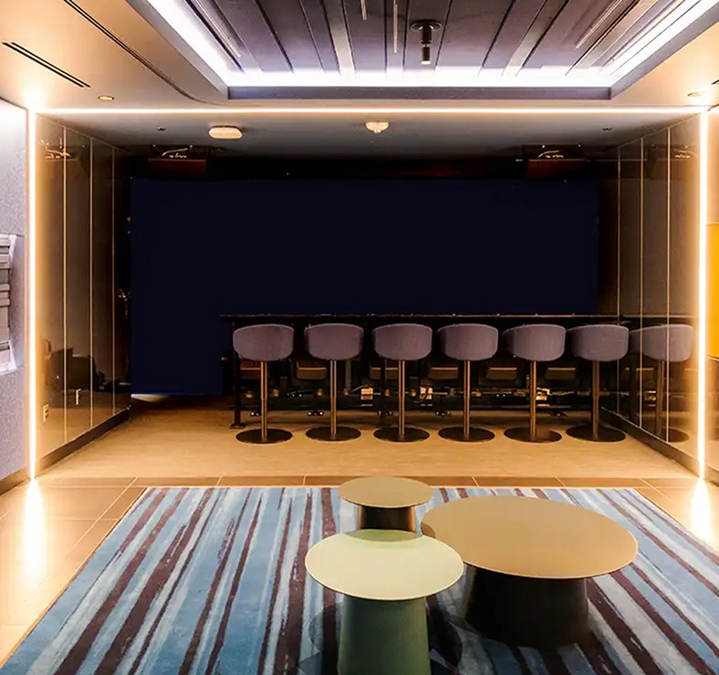 Exterior of a converted industrial warehouse nightclub at night, raw brick facade, heavy steel doors, warm golden light spilling from entrance, dark urban street, black and white photography, selective color gold only on entrance light and signage glow