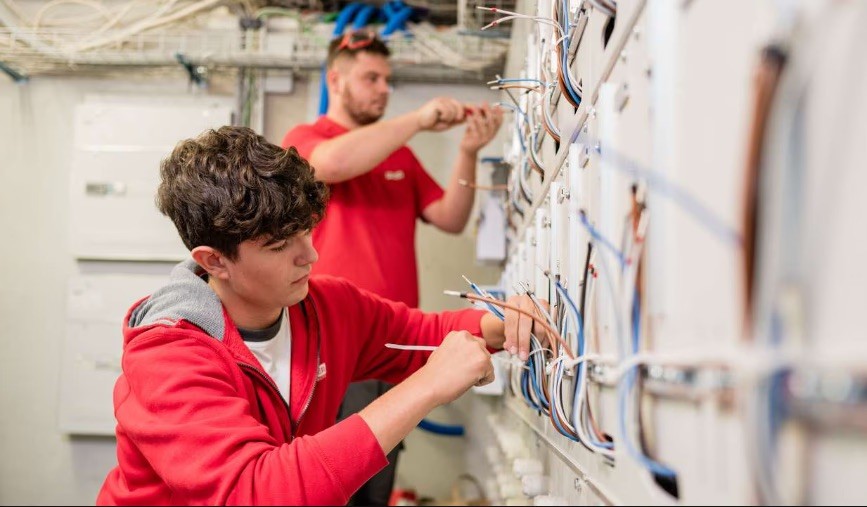 Deux collaborateurs travaillent sur des installations électriques ouvertes