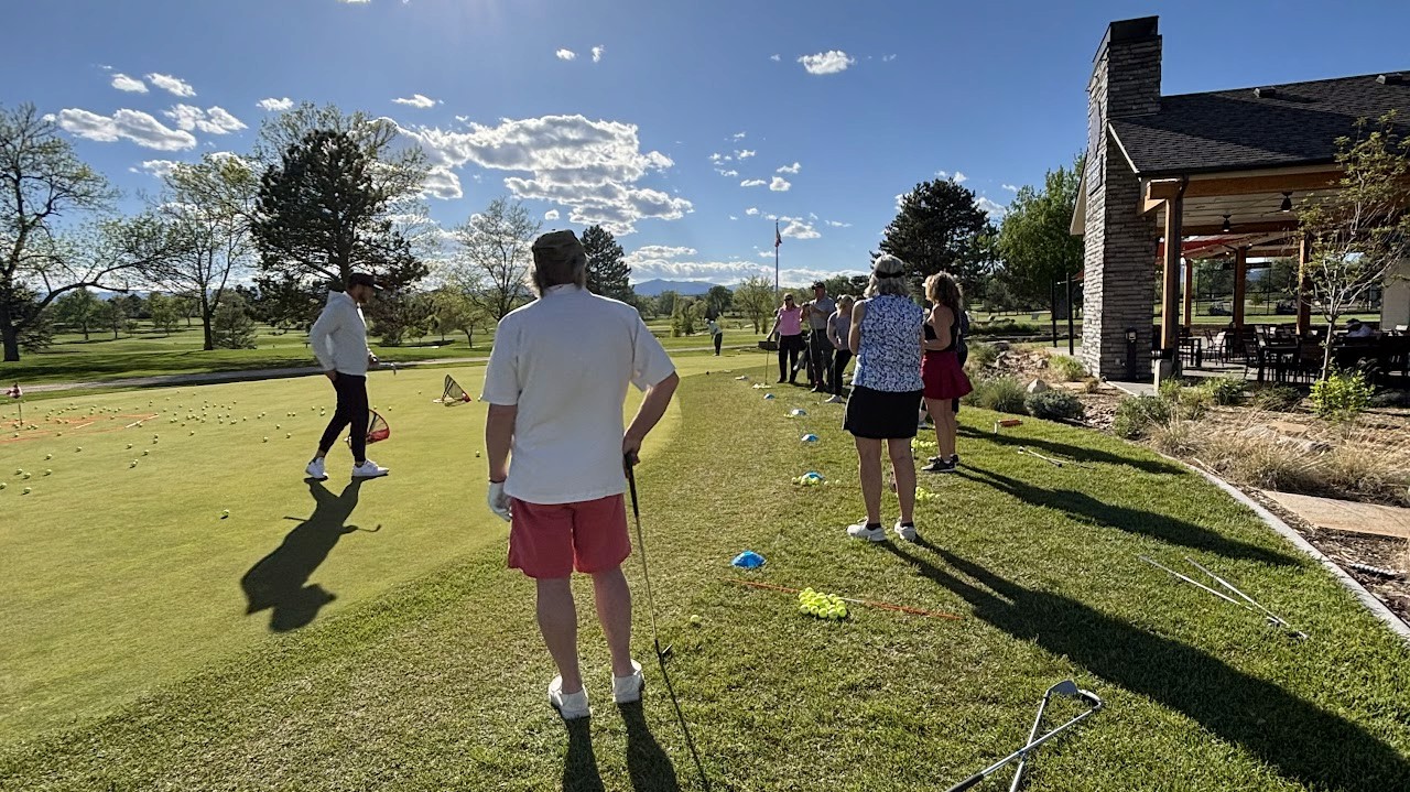 A group of students on the edge of a green, going through chipping exercises. 