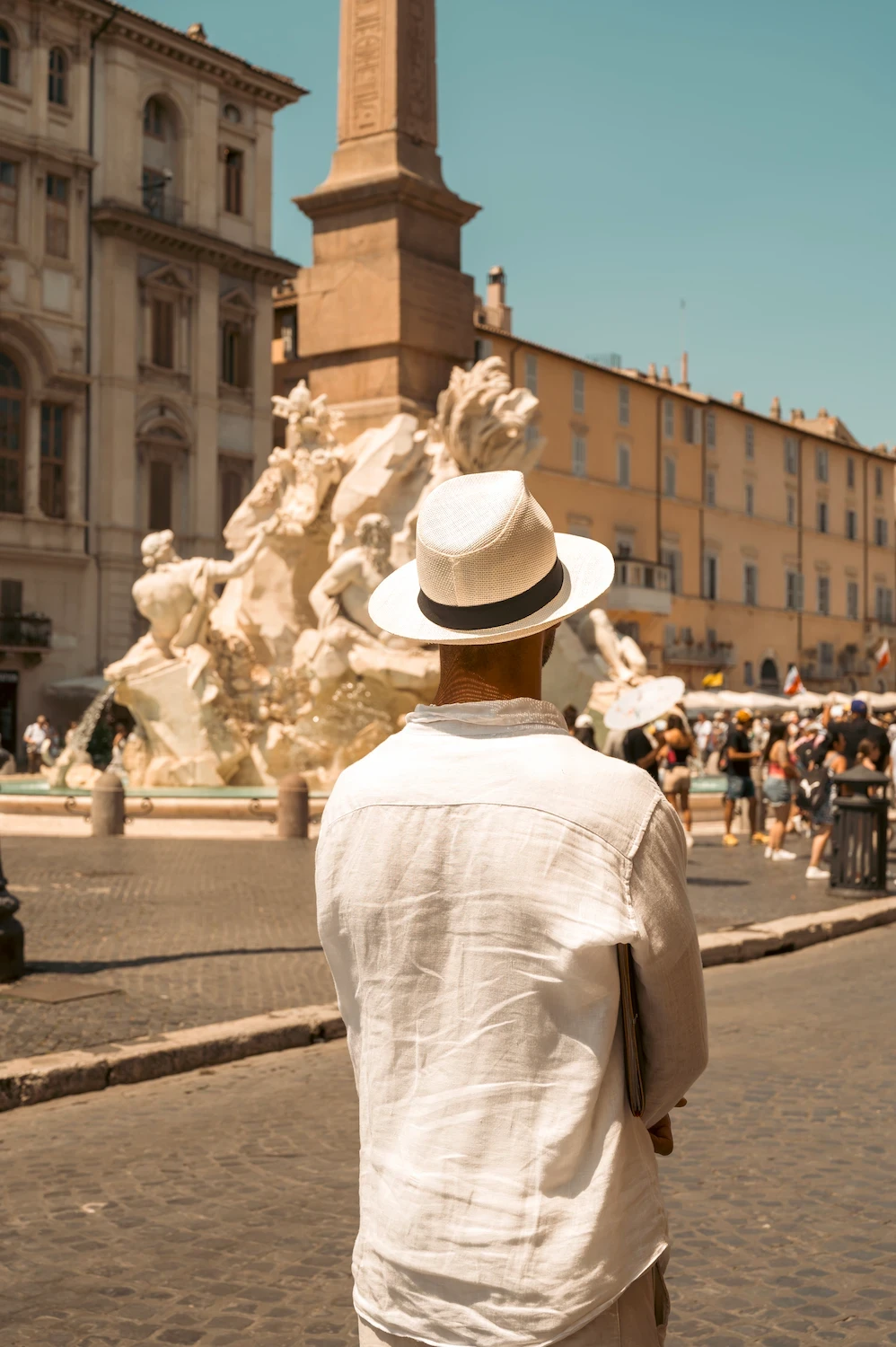 Uomo di spalle vestito di bianco mentre guarda Piazza Navona