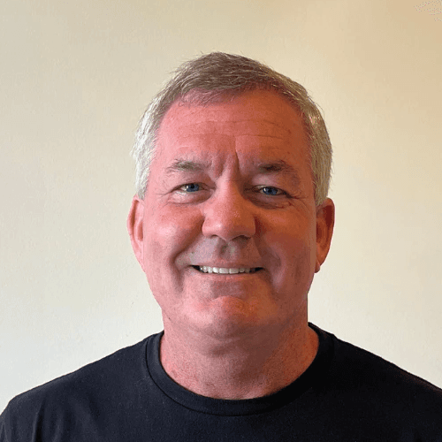 A headshot of a smiling client against an office wall.
