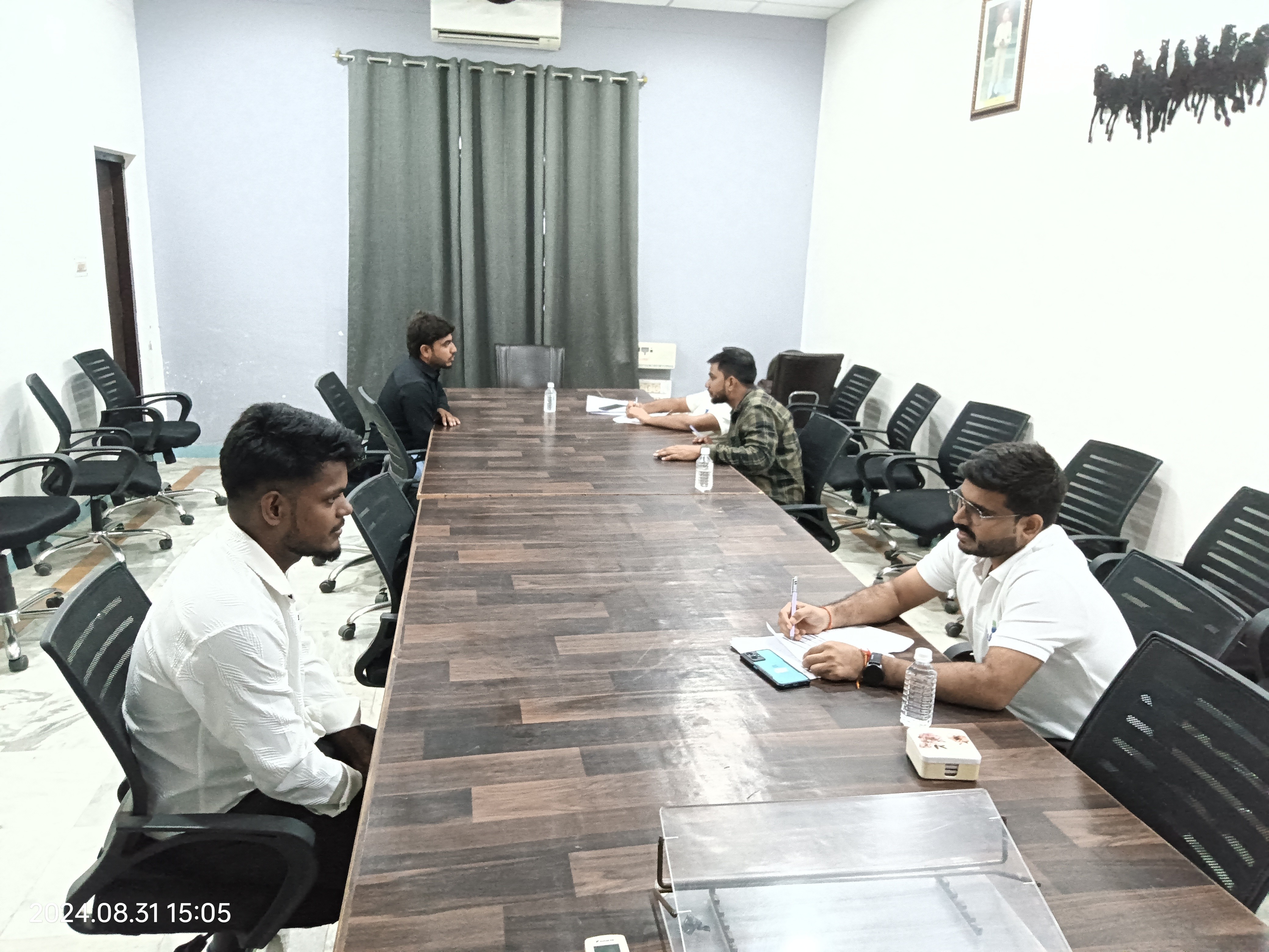 people sitting on chair in front of table while holding pens during daytime