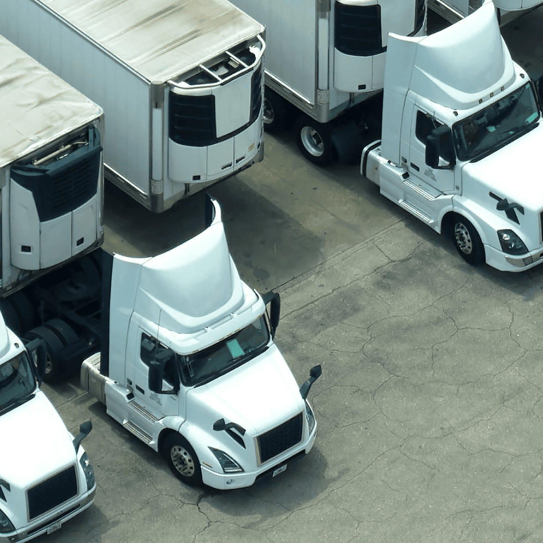 Semi-trucks parked in distribution yard coordinated through yard management system