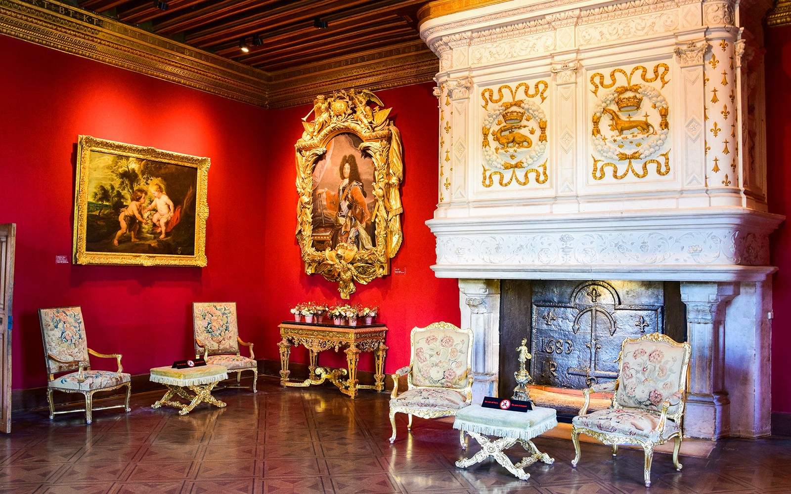 Chenonceau Castle interior with ornate fireplace and classic paintings.