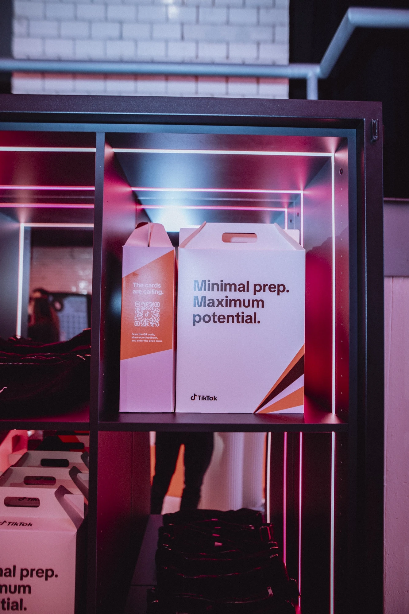 White goodie boxes reading Minimal prep maximum potential in a shelf with red light strips.