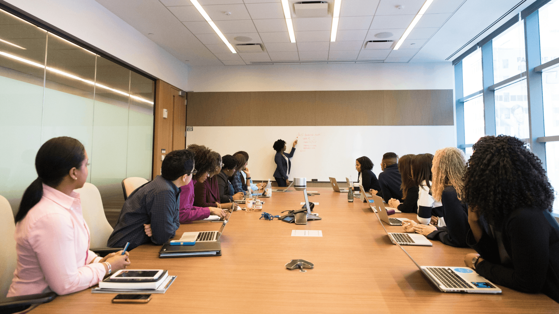 A group of managers collaborating during a presentation, symbolising the managerial middle translating AI strategy into practical action