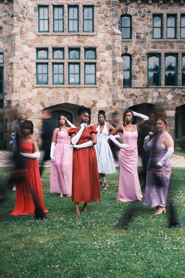 Women in formal dresses gathered on a lawn