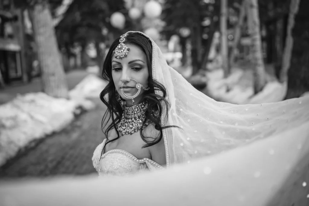 Black-and-white portrait of a bride wearing ornate jewelry