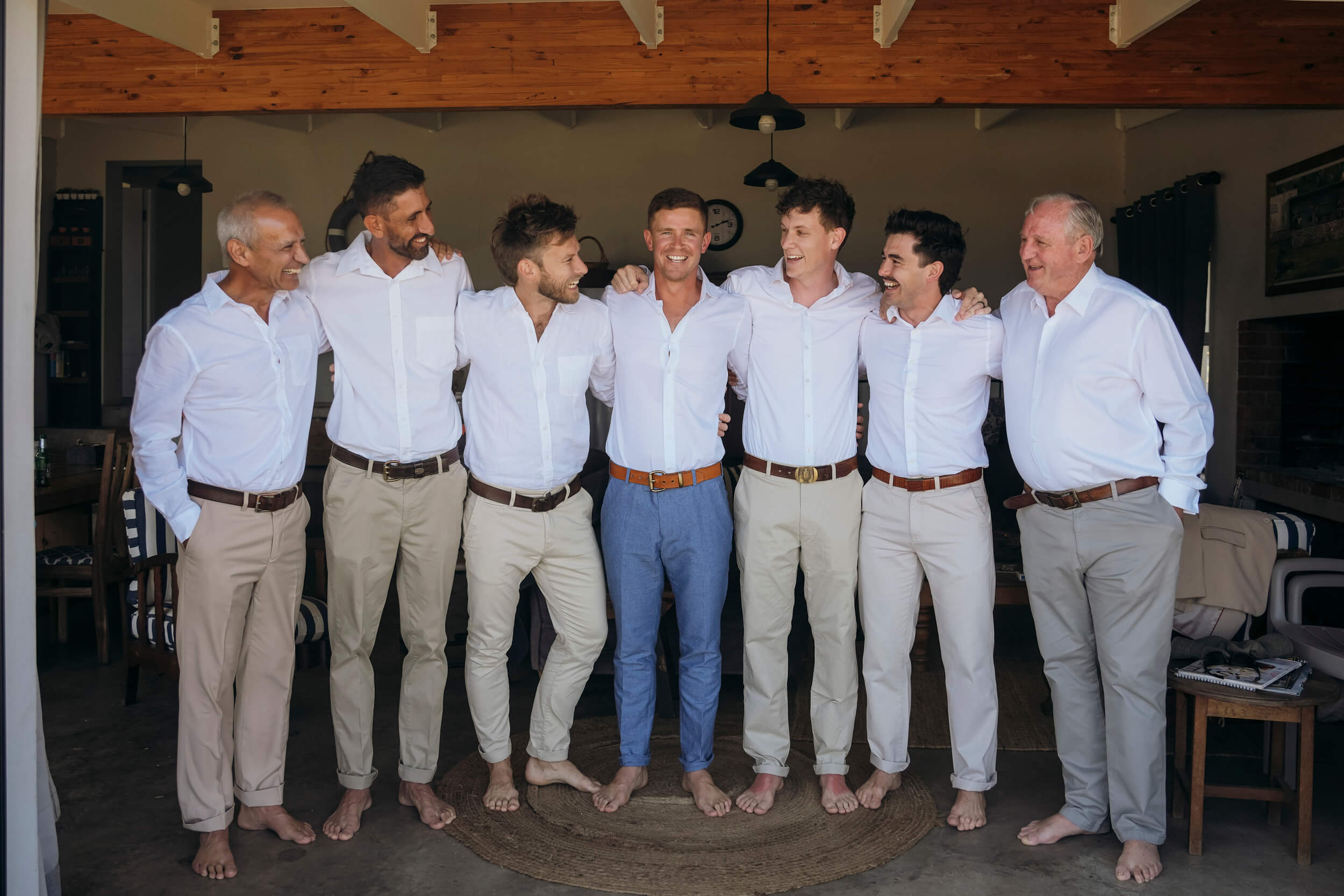 Groom with groomsmen smiling together before Cape St Francis wedding ceremony