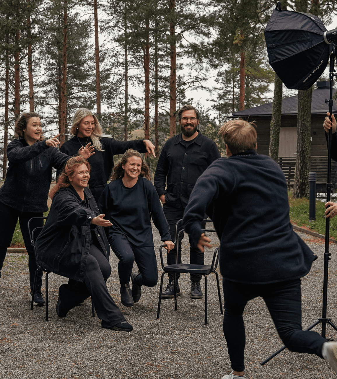 Bild på 6 personer som förbereder en gruppbild, alla i svarta kläder