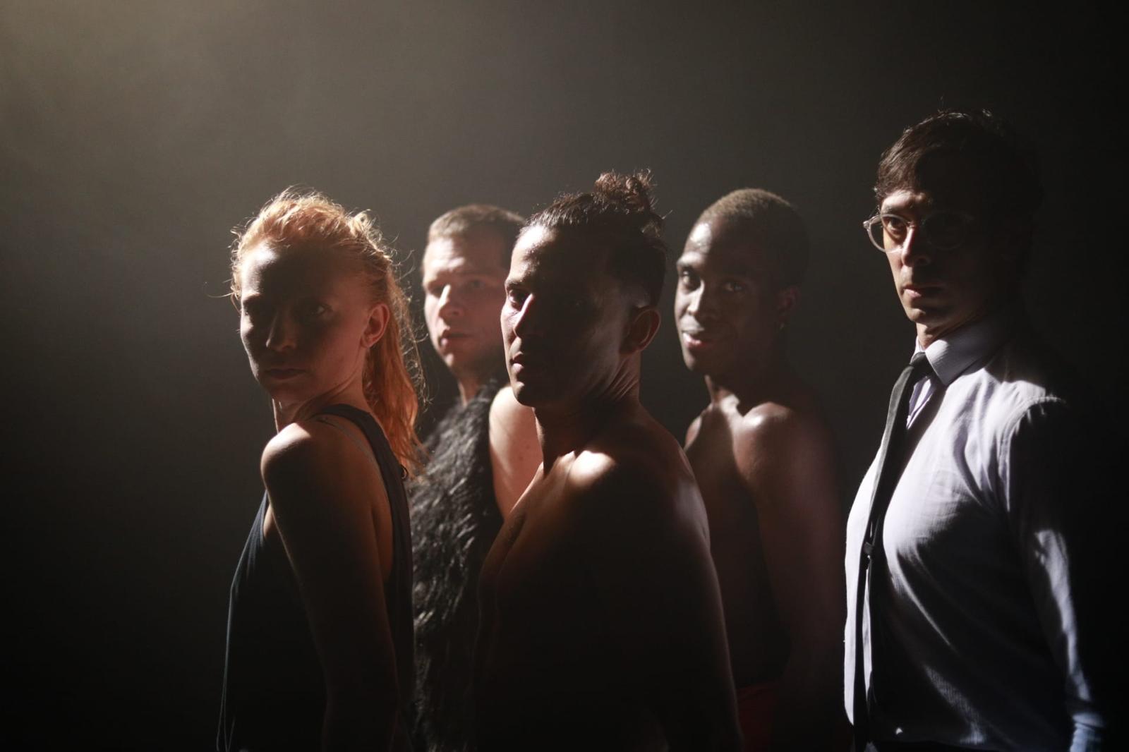 Woman in pink leather jacket crouching outdoors at night