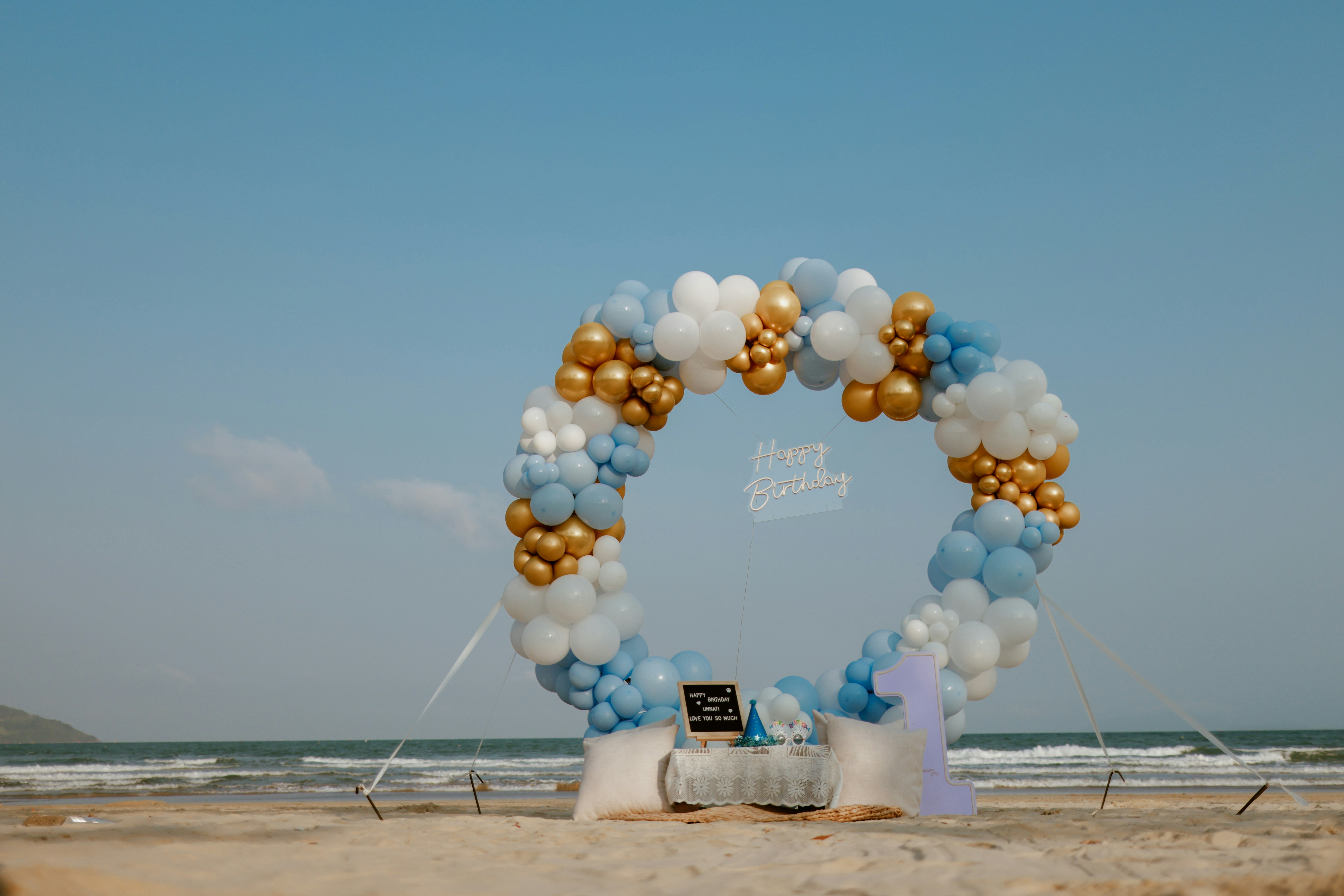 Circular balloon arch on a beach with ocean background