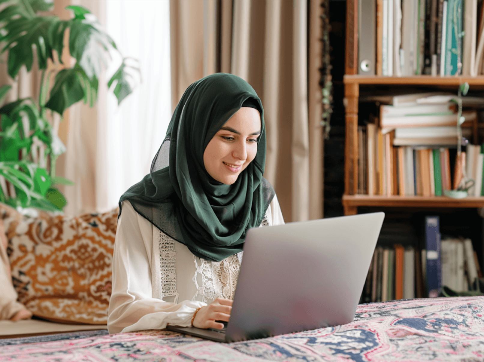 Muslim woman on laptop in a living room.