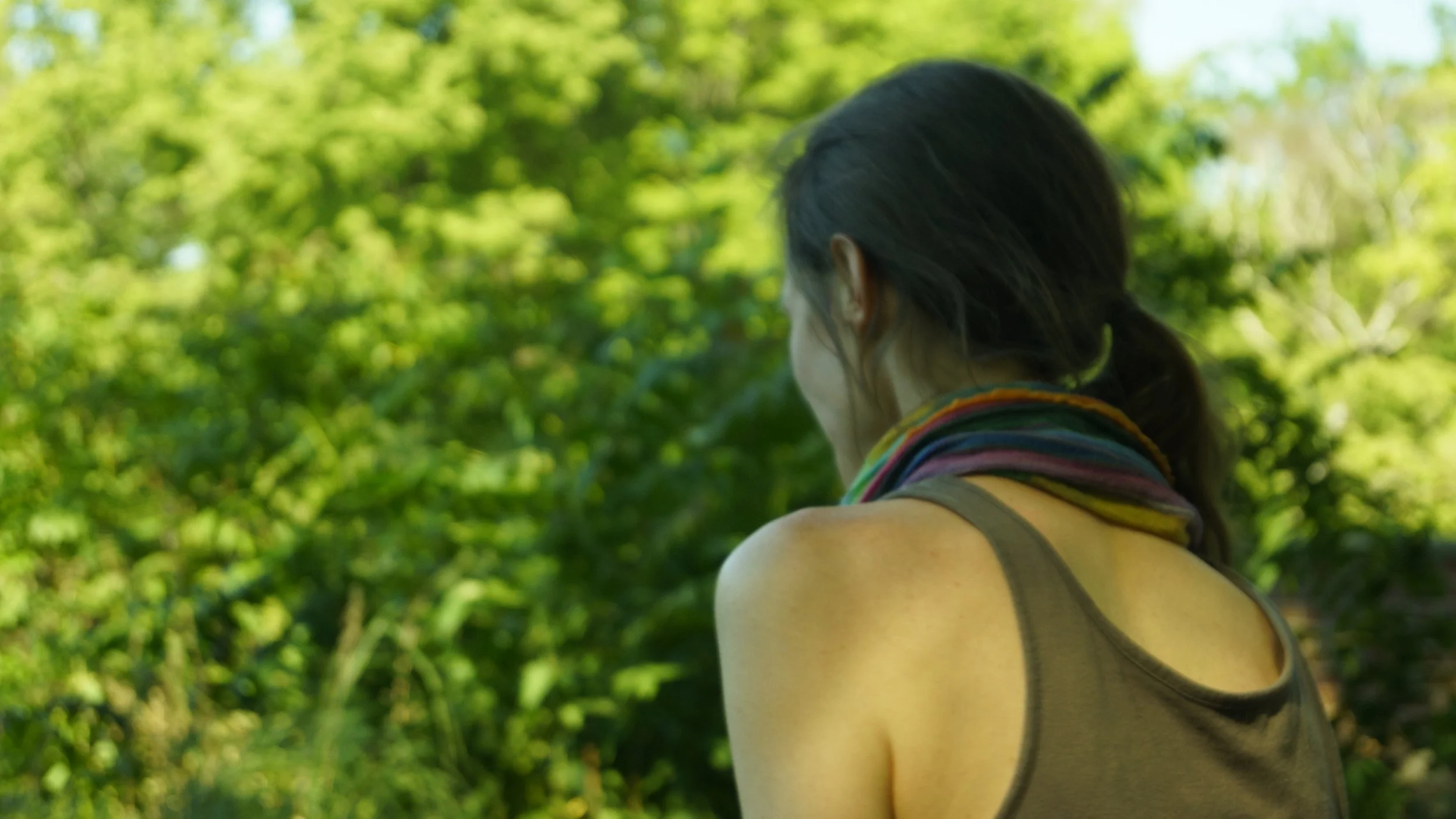 leicht verschwommene Nahaufnahme von Karina Gaurangis Hinterkopf, mit grünem Hintergrund (verschwommene Pflanzen)