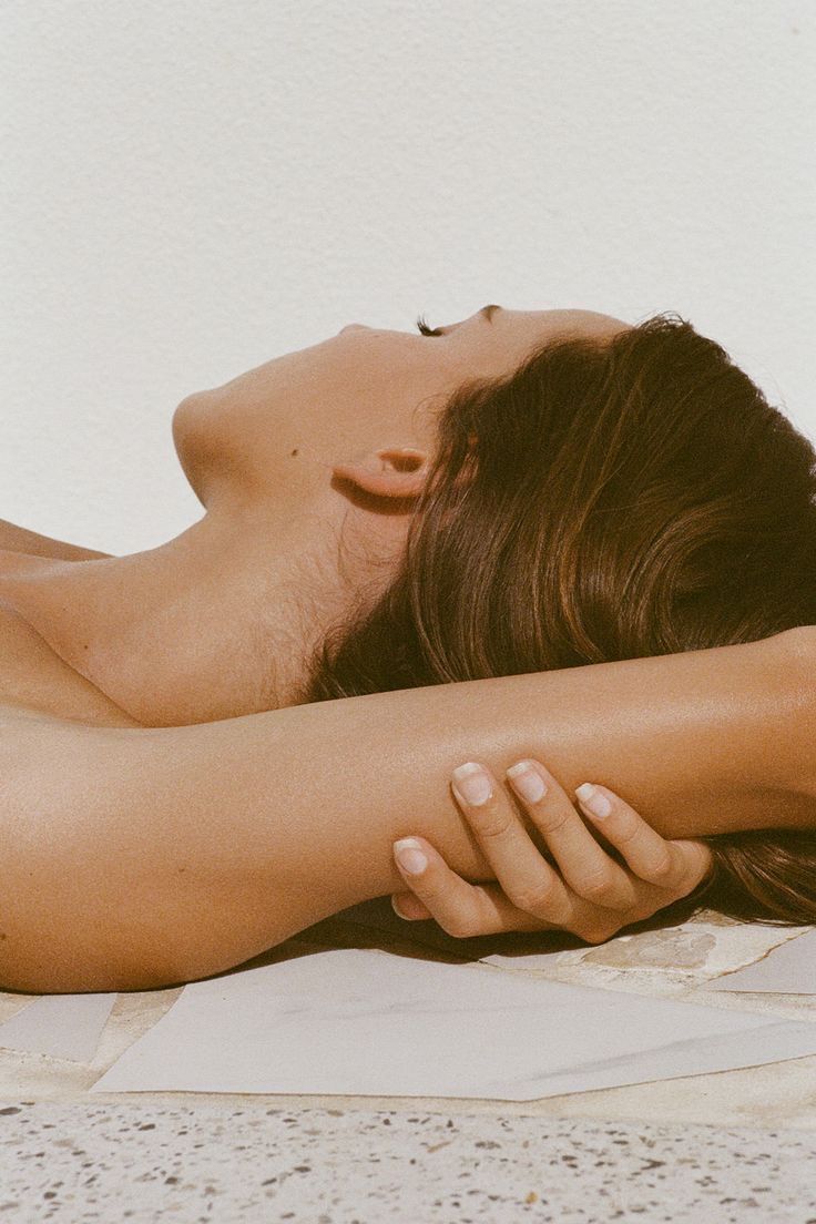 3D render of an abstract translucent glass sculpture with smooth, flowing organic curves floating against a minimal light gray background. The form resembles a fluid, molten loop with soft reflections and refractions