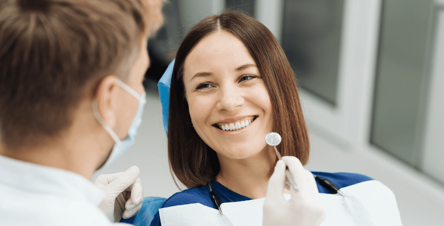 A dentist and a smiling patient discussing dental care during a consultation