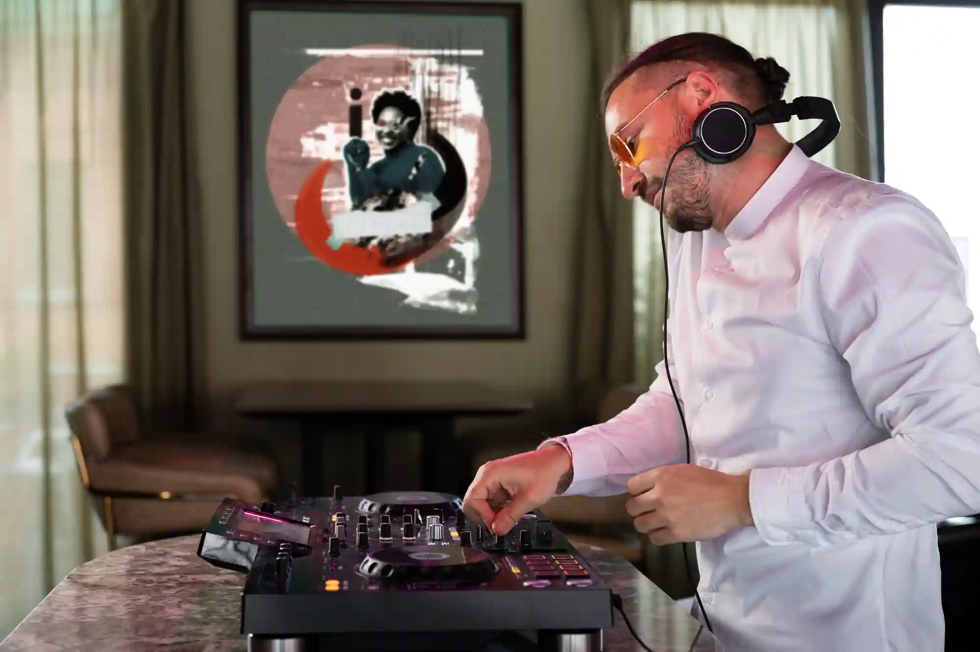 A man DJs with a poster in the background.