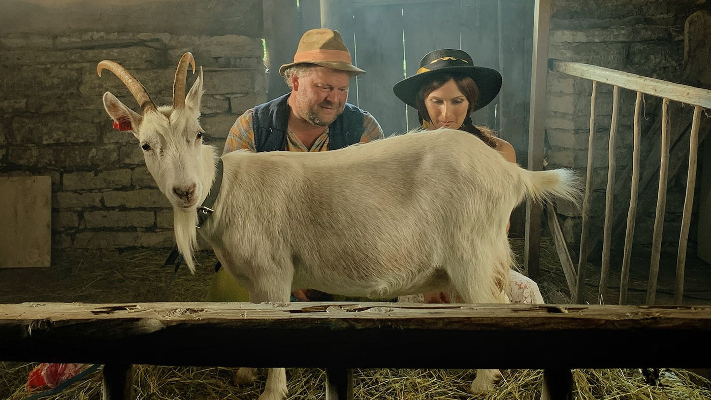 two heroes from the vacationers are looking at the goat not knowing how to interact with the animals