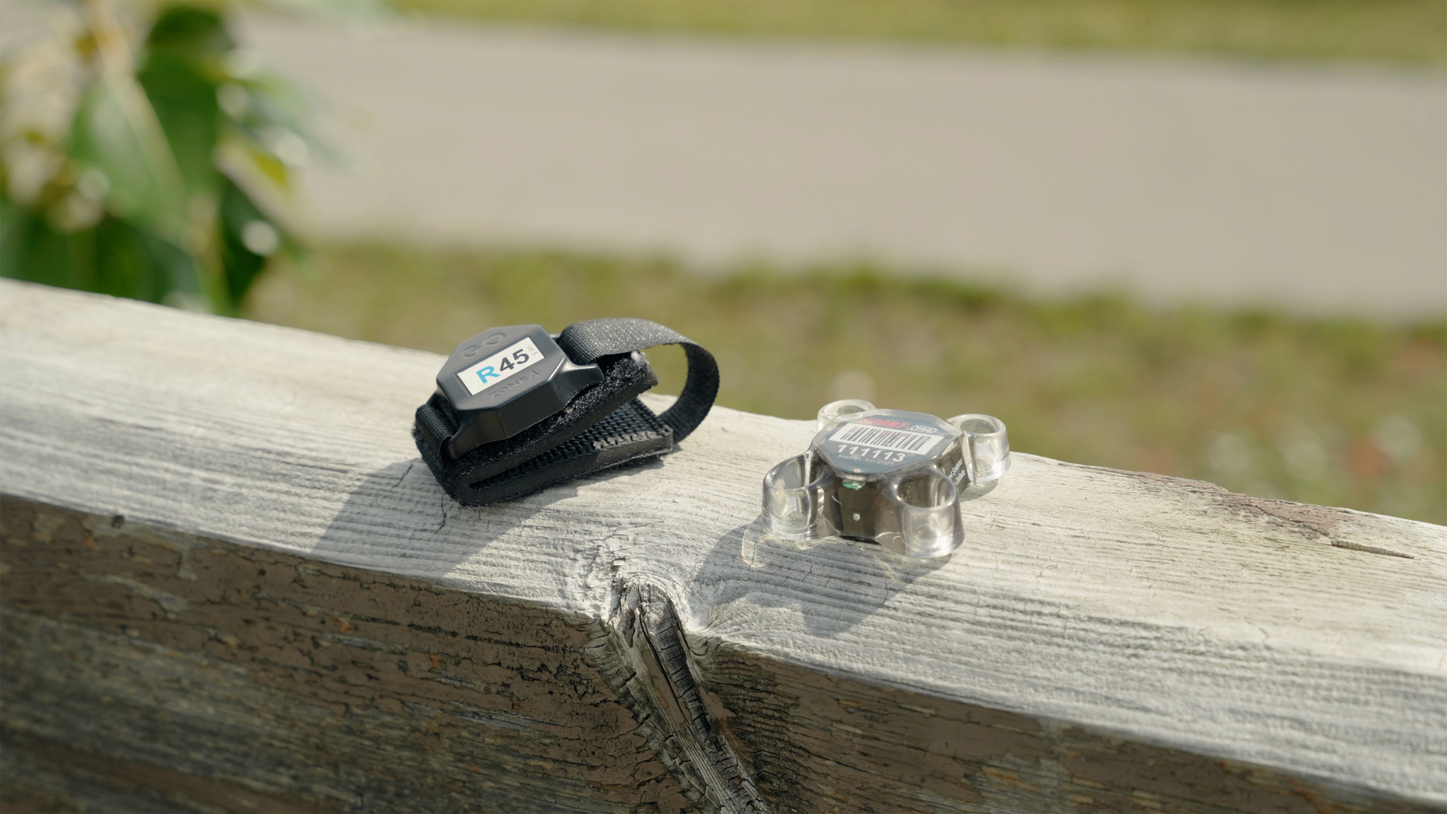 Zone4 race timer chip and Motorcycle chip sit beside each other on a wood railing