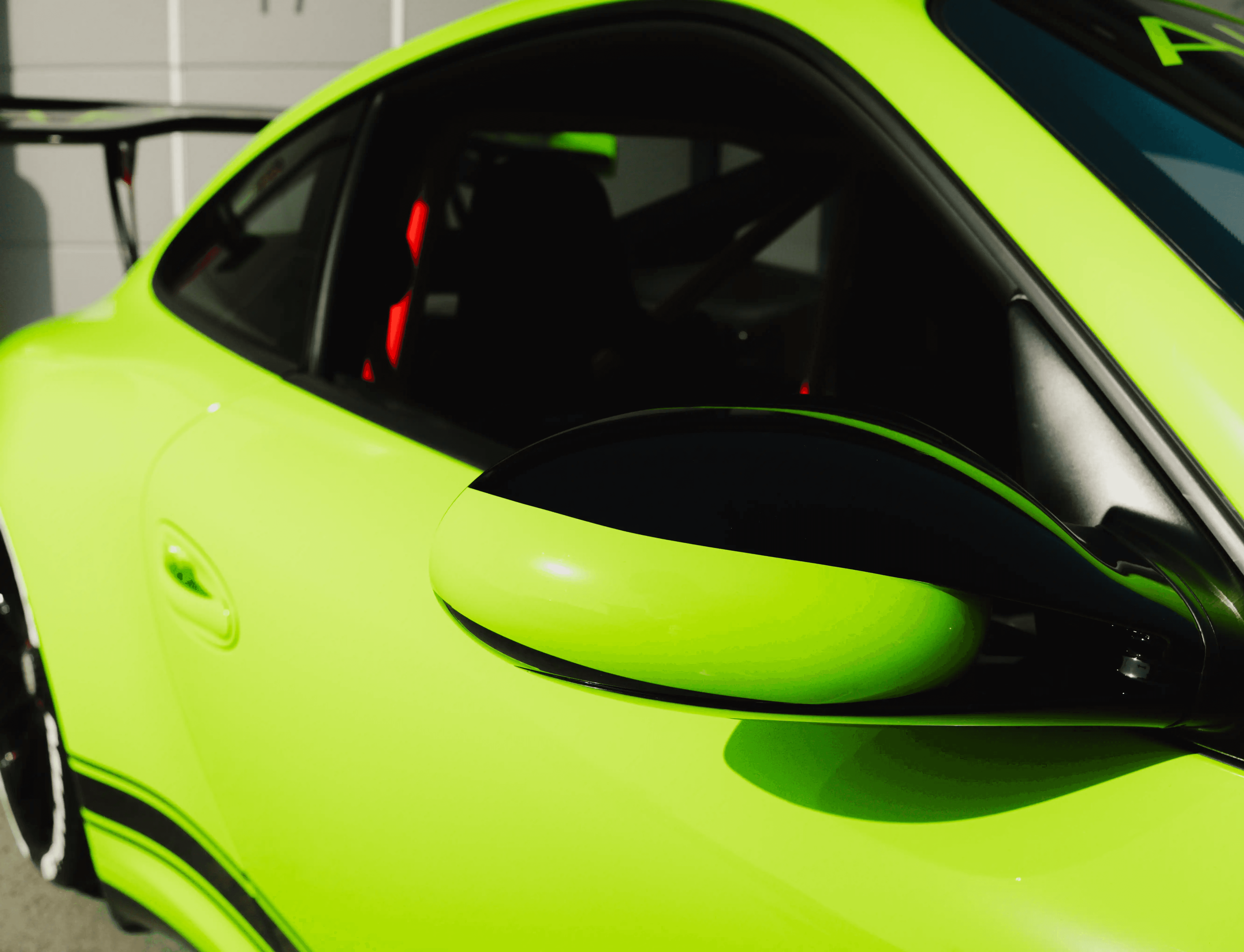 Außenspiegel eines Porsche GT3 RS in Signalgrün mit schwarzen Akzenten