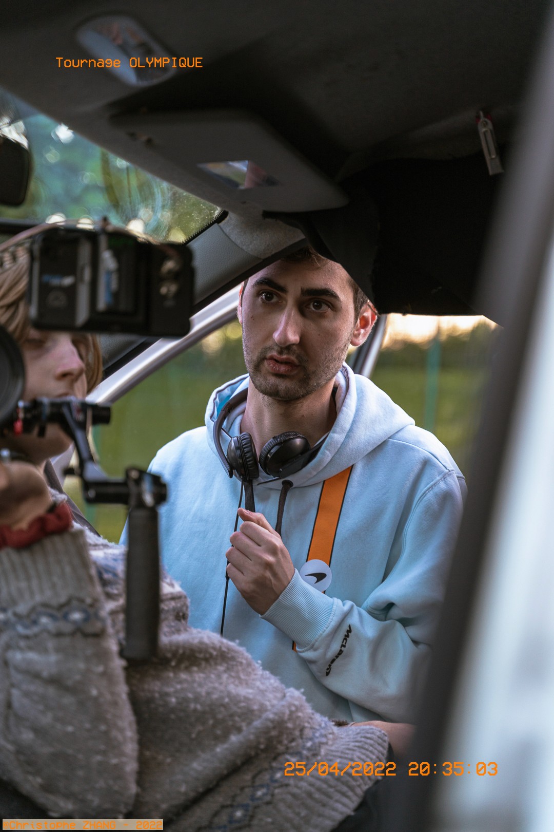 Réalisateur concentré lors d’une scène filmée à l’intérieur d’une voiture.