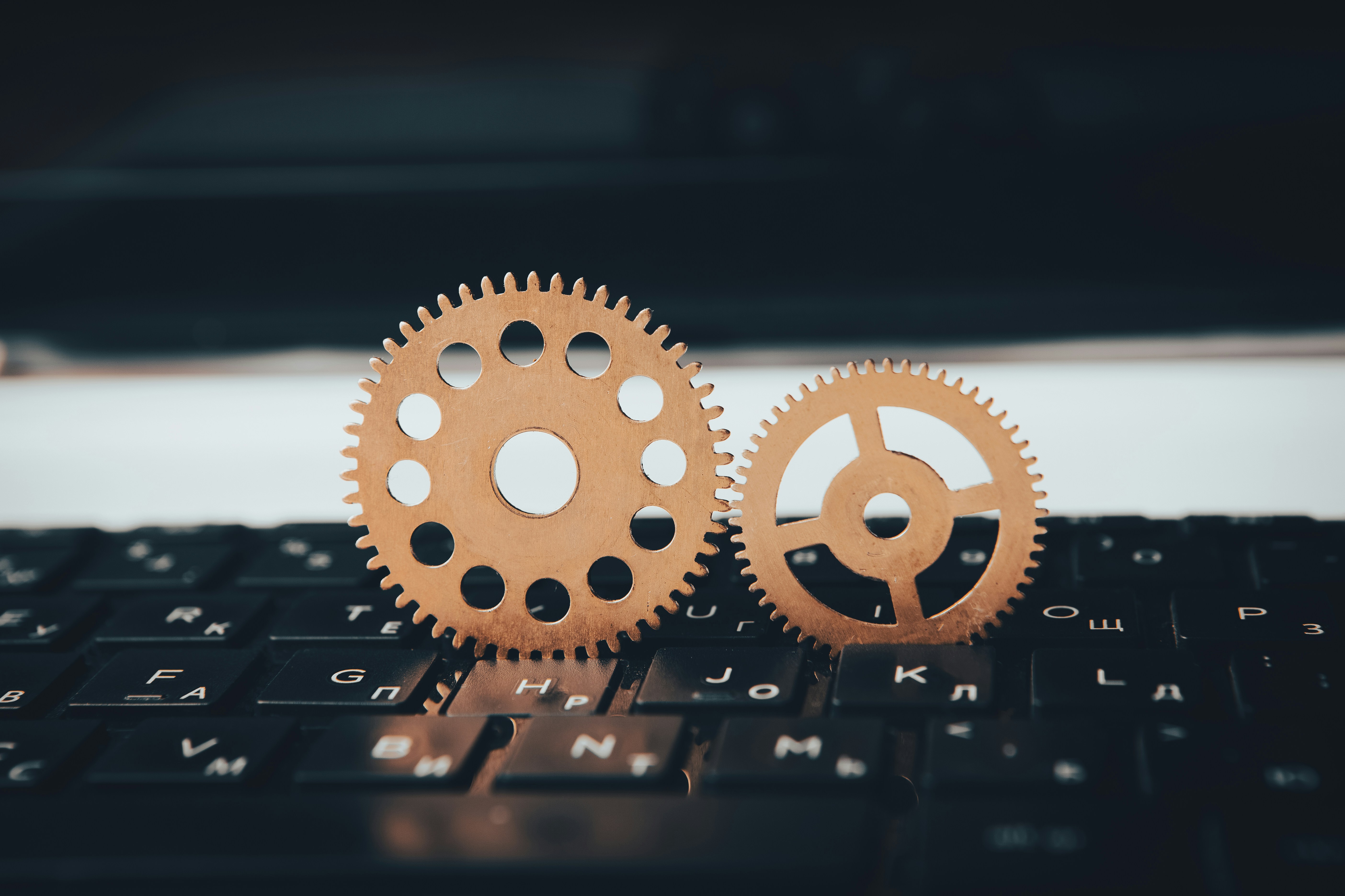 Two wooden gears sitting on top of a keyboard