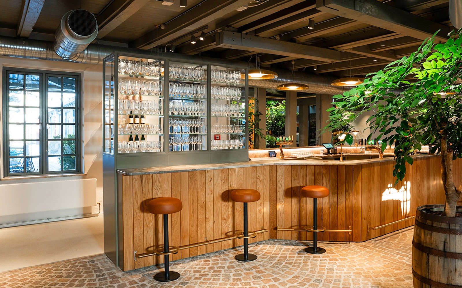 Bárterület bárszékekkel és üveges kiállítással a Carlsberg Otthona kiállításon belül.