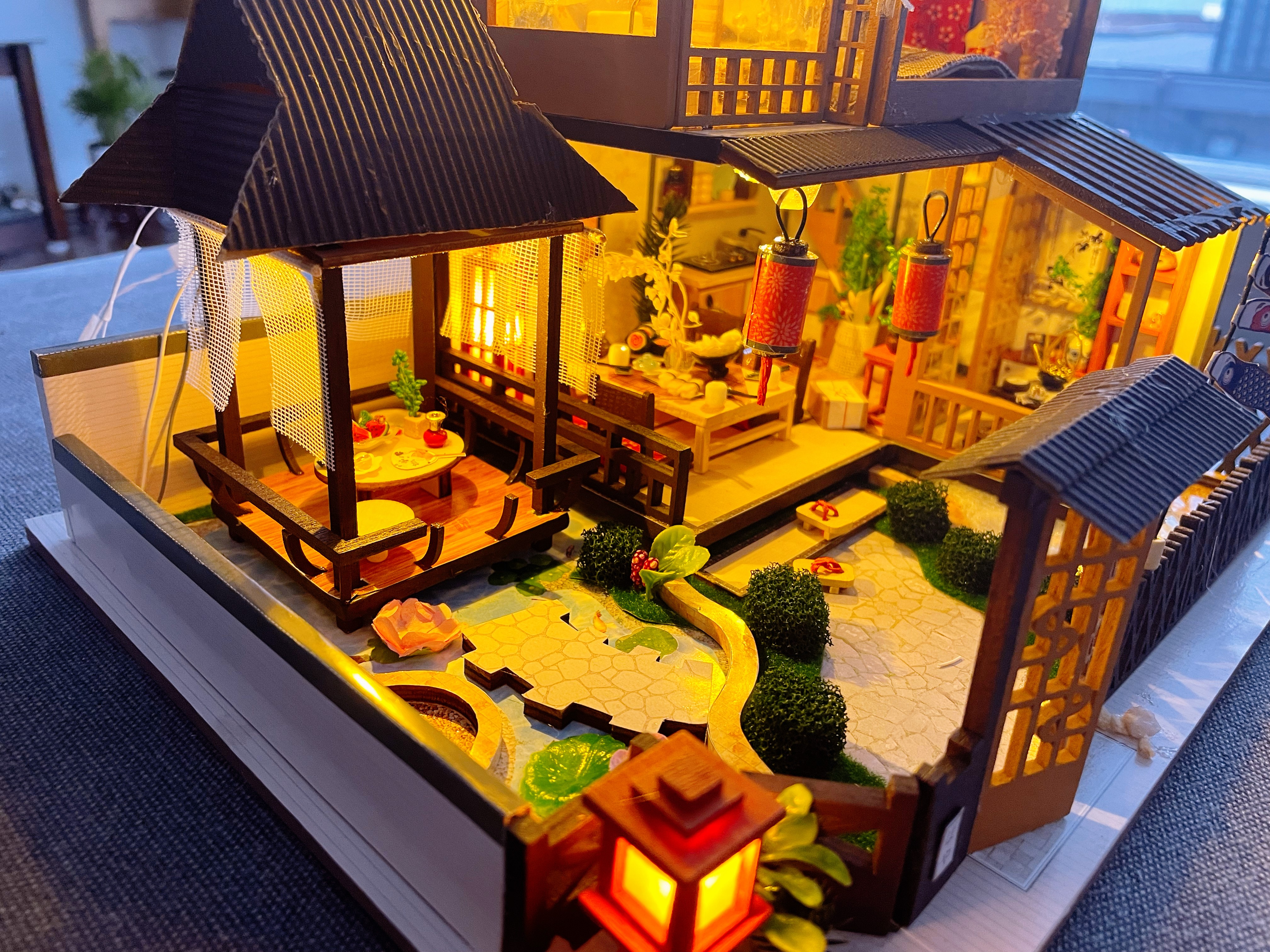 Miniature model of a traditional Japanese tea house with wooden details, sliding shoji doors, and a serene interior