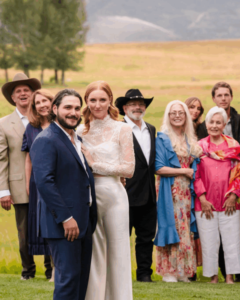 Newlyweds posing with wedding guests outdoors