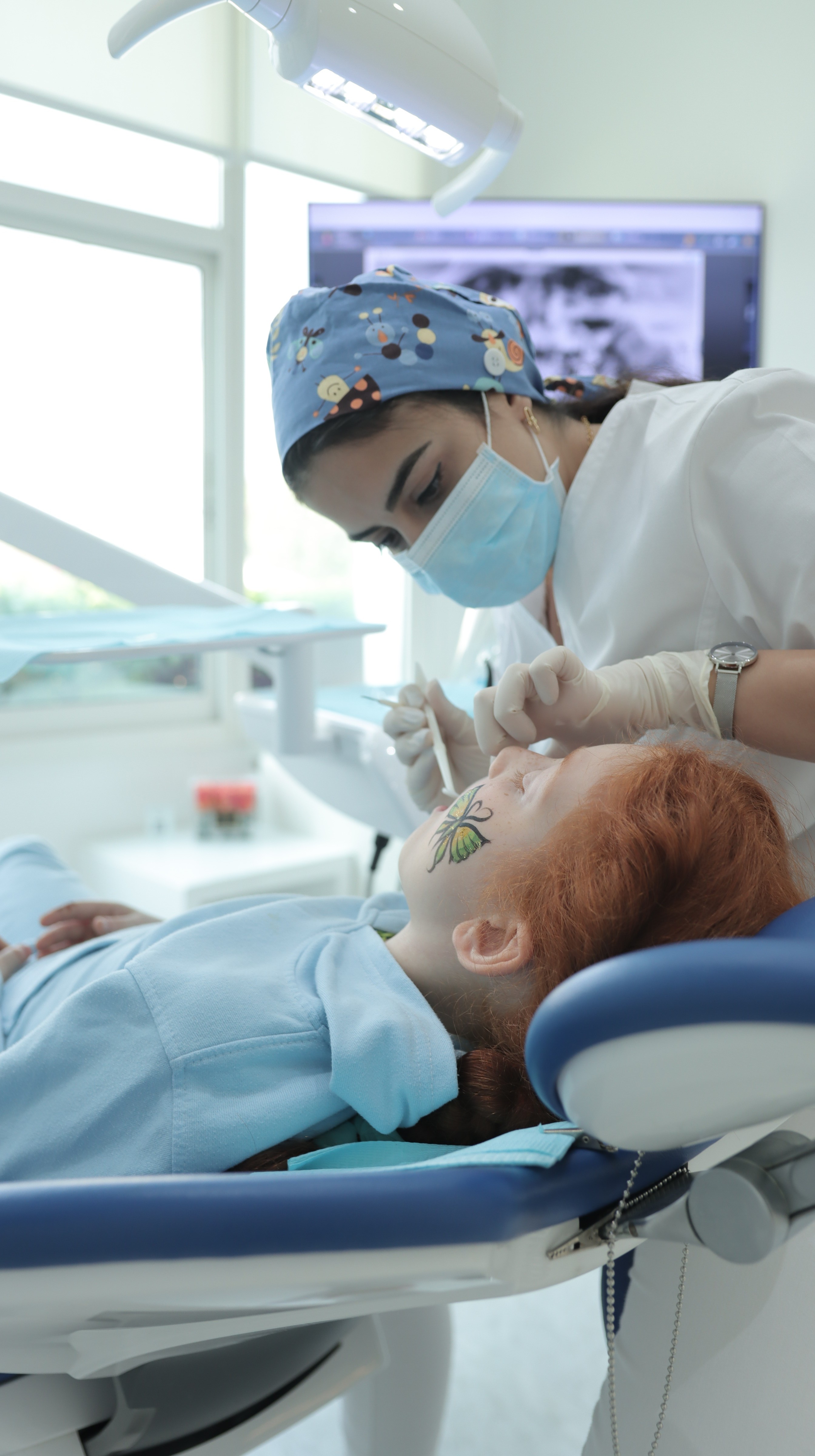 A pediatric dentist performs teeth cleaning for children, removing buildup while keeping young patients relaxed and comfortable.
