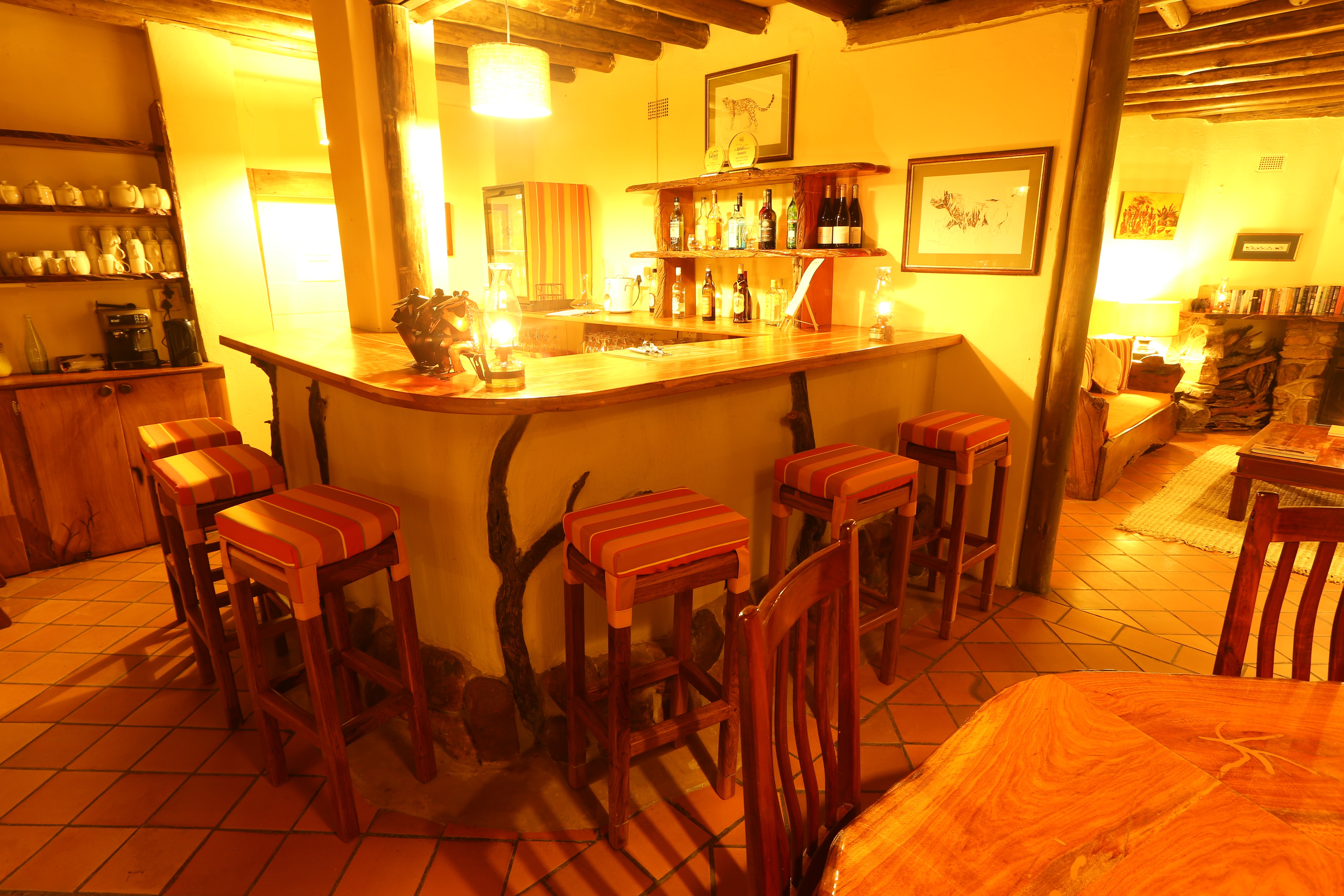 Grupp av ryttare på ridresa i Afrika galopperar över Serengetis vidsträckta slätter medan damm och gnuhjordar rör sig över horisonten under the great migration.